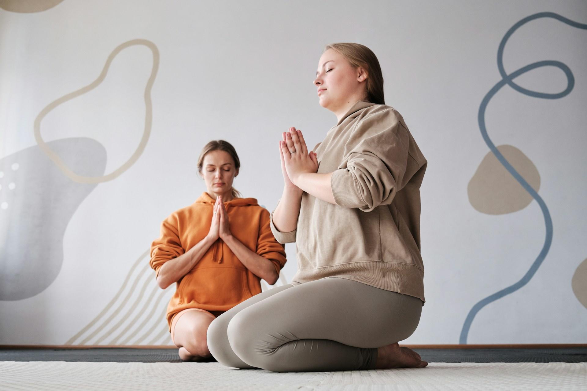 mulheres sentadas praticando meditação