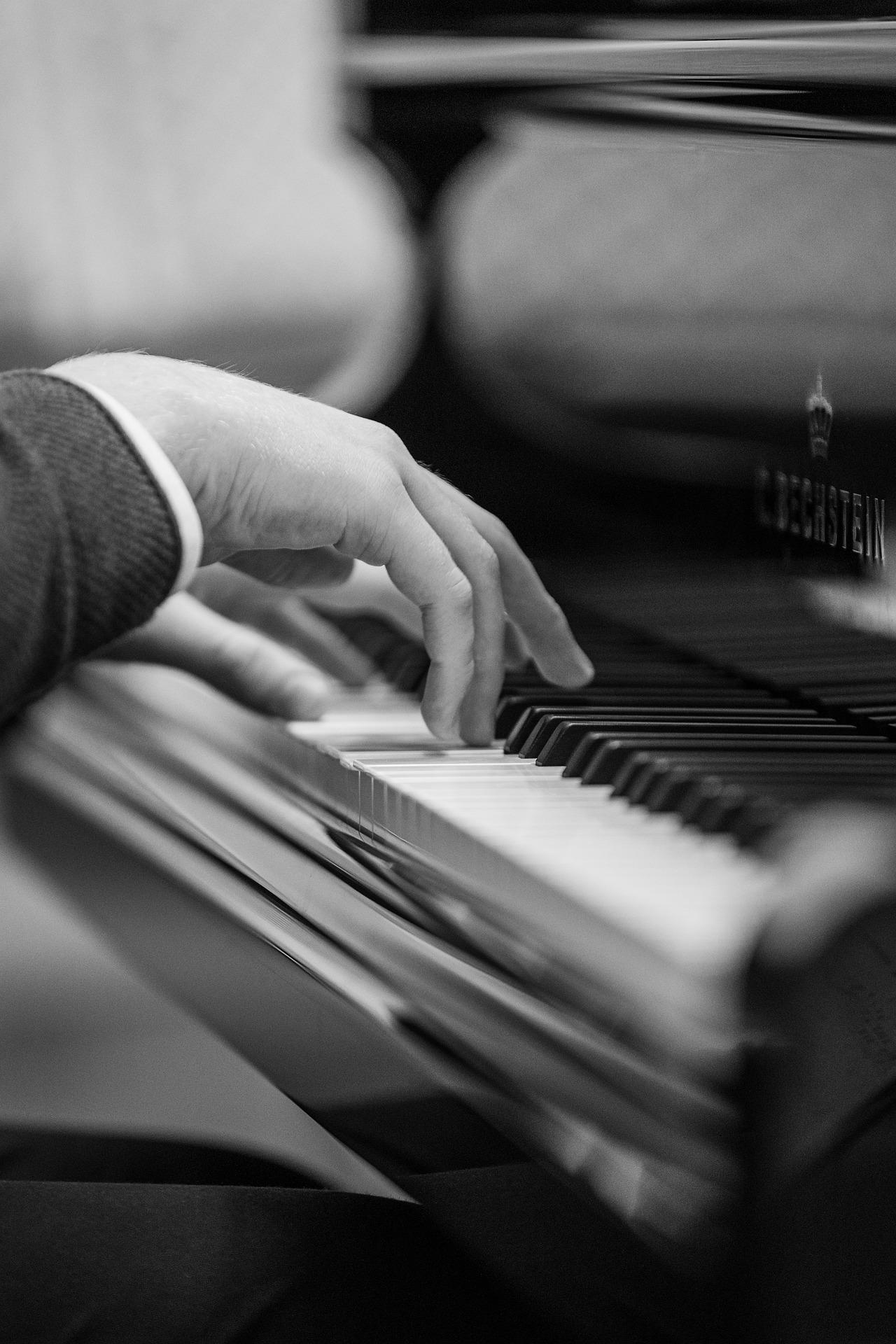 mãos masculinas tocando um piano