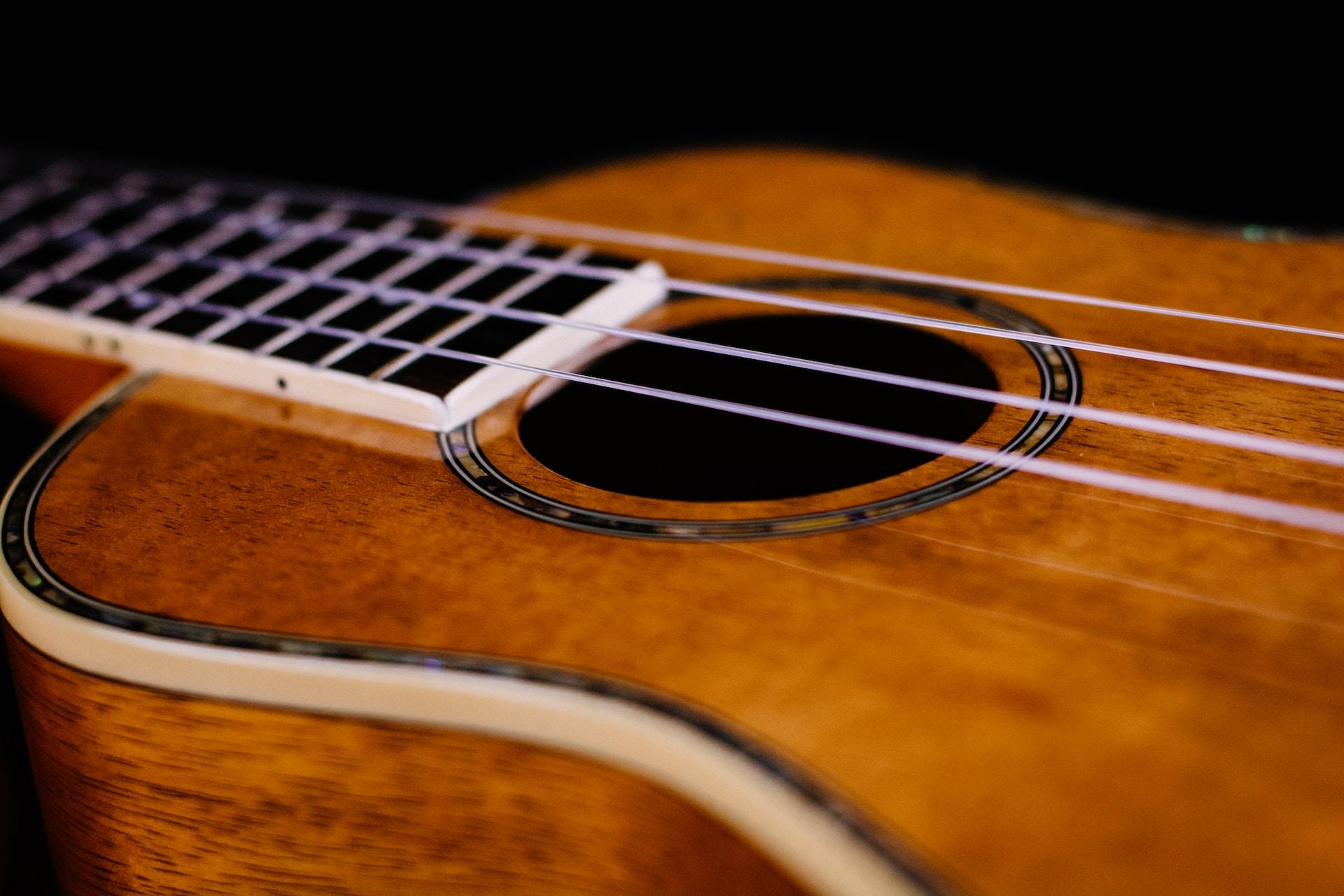 Foto de um cavaquinho cor carvalho, madeira.