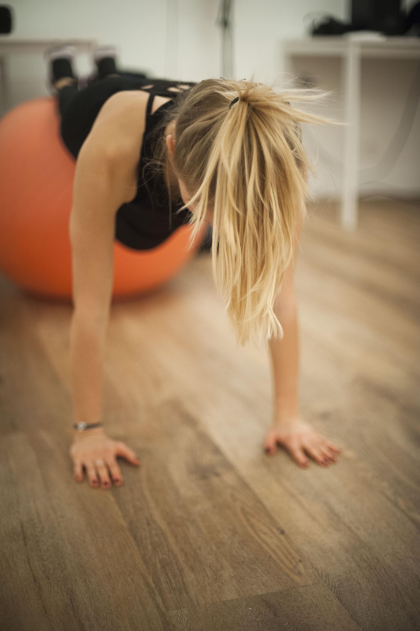 Mulher fazendo prancha em uma bola de pilates.