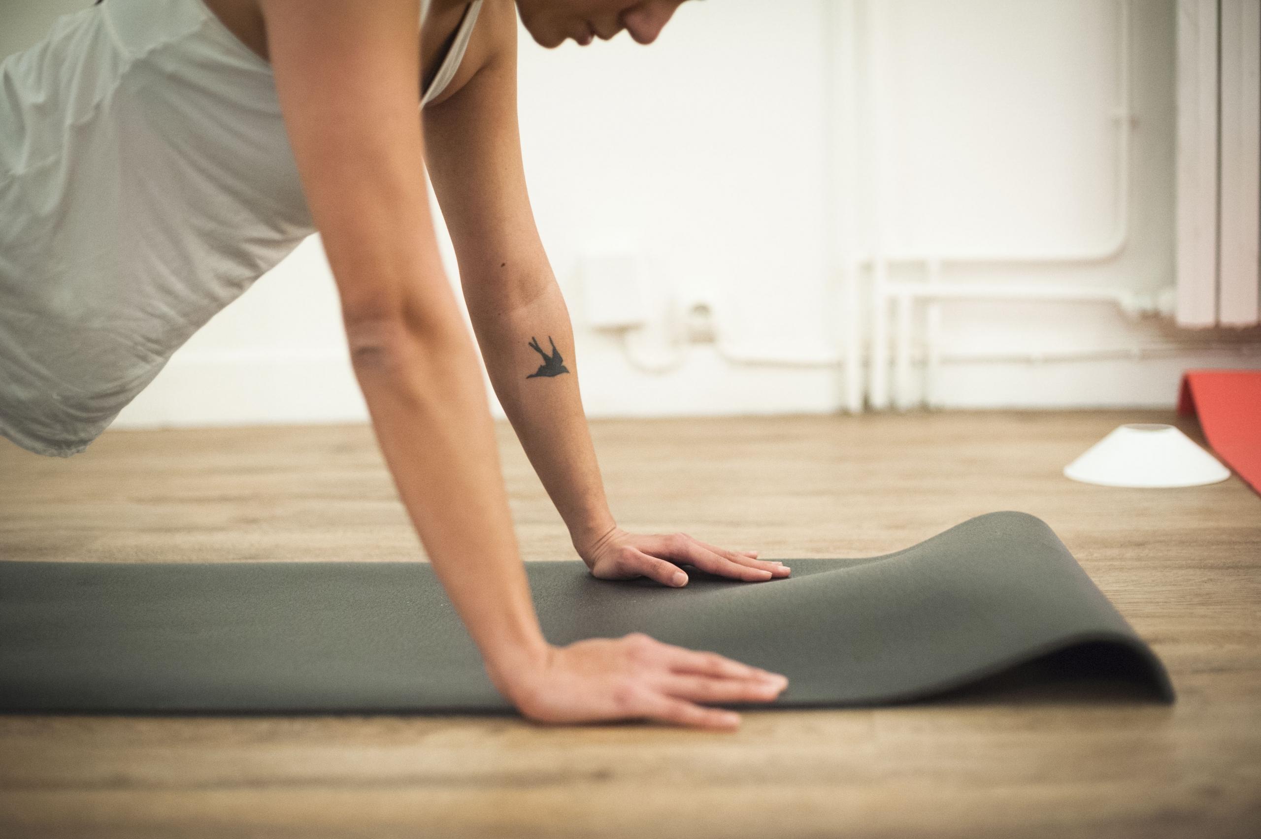 Mulher fazendo um exercício de prancha em uma colchonete.