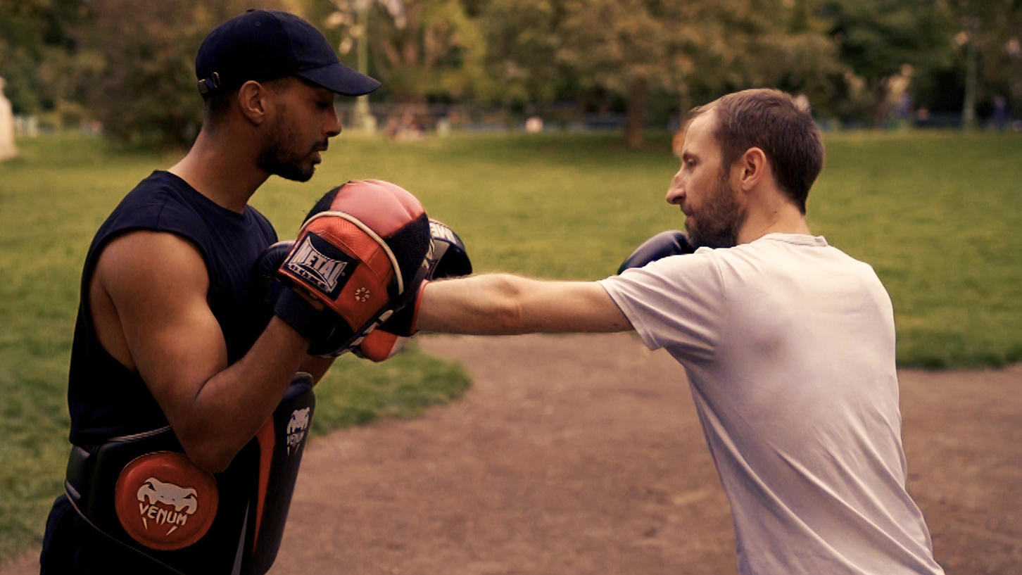 Homens treinando boxe em um parque.