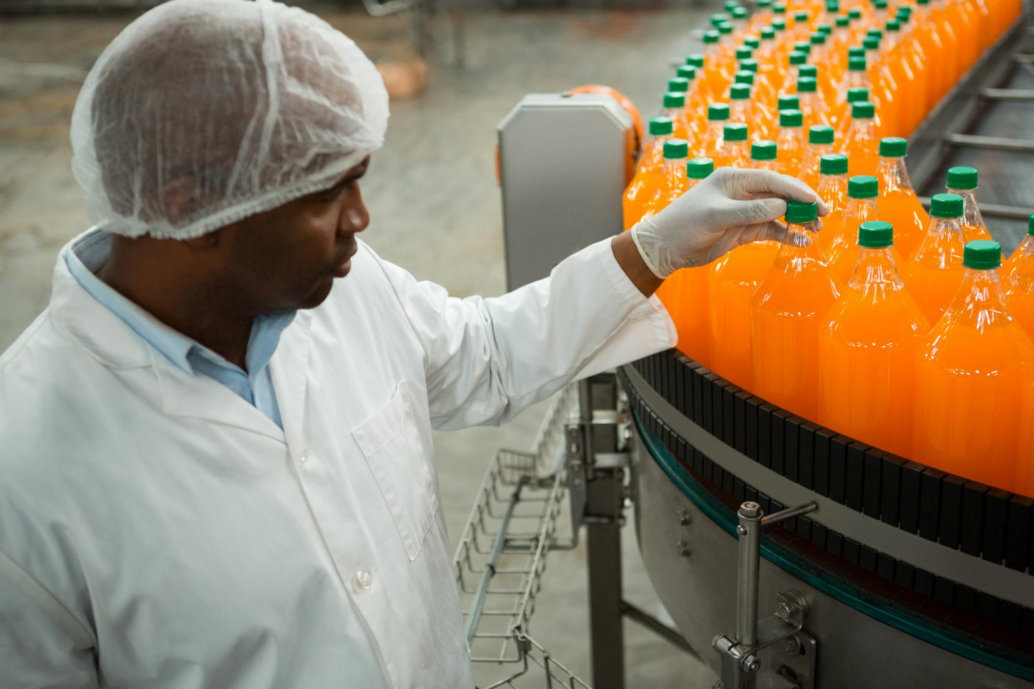 Profissional ao lado de maquinário na indústria alimentícia
