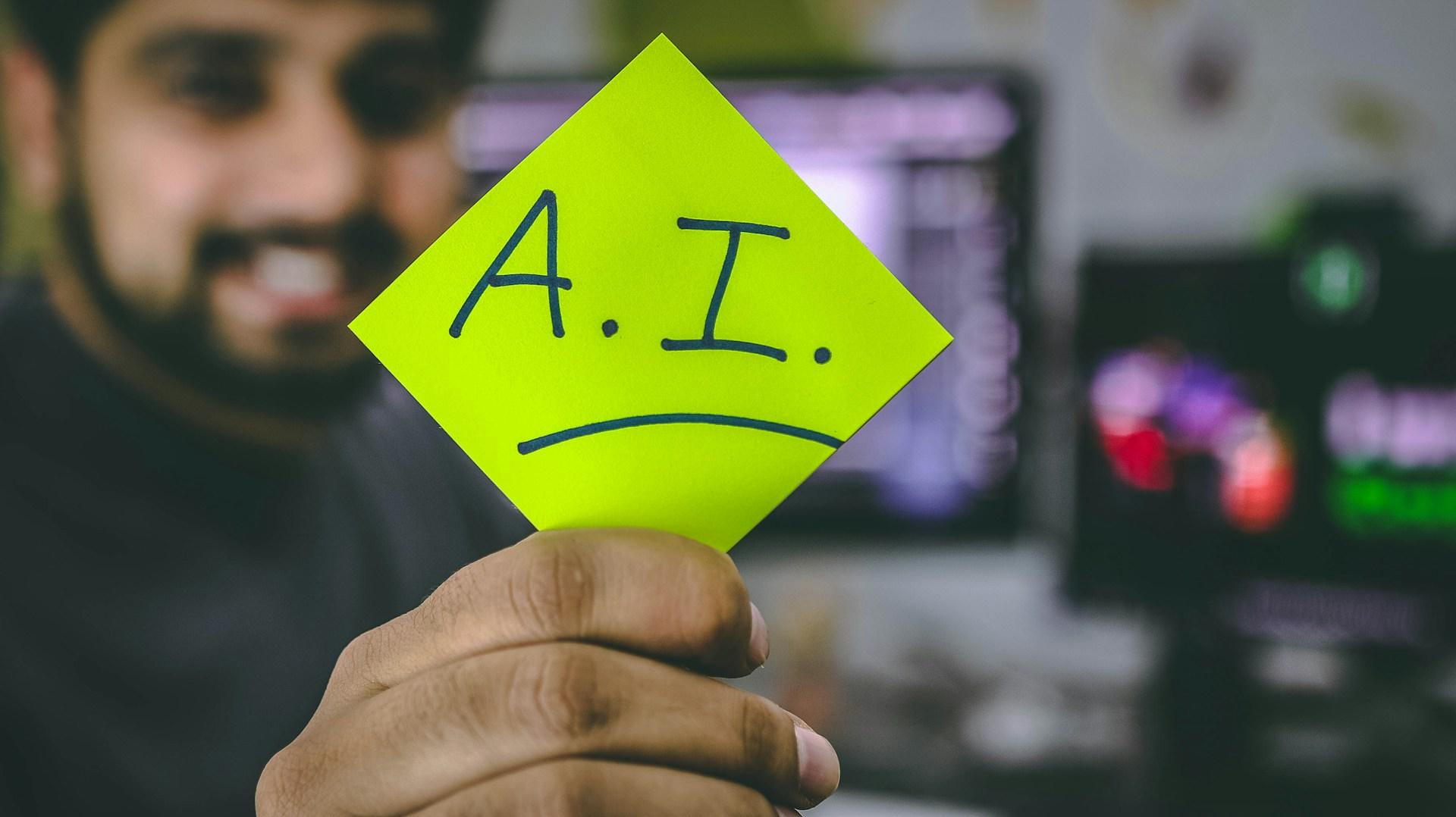 Homem segurando um post-it escrito AI