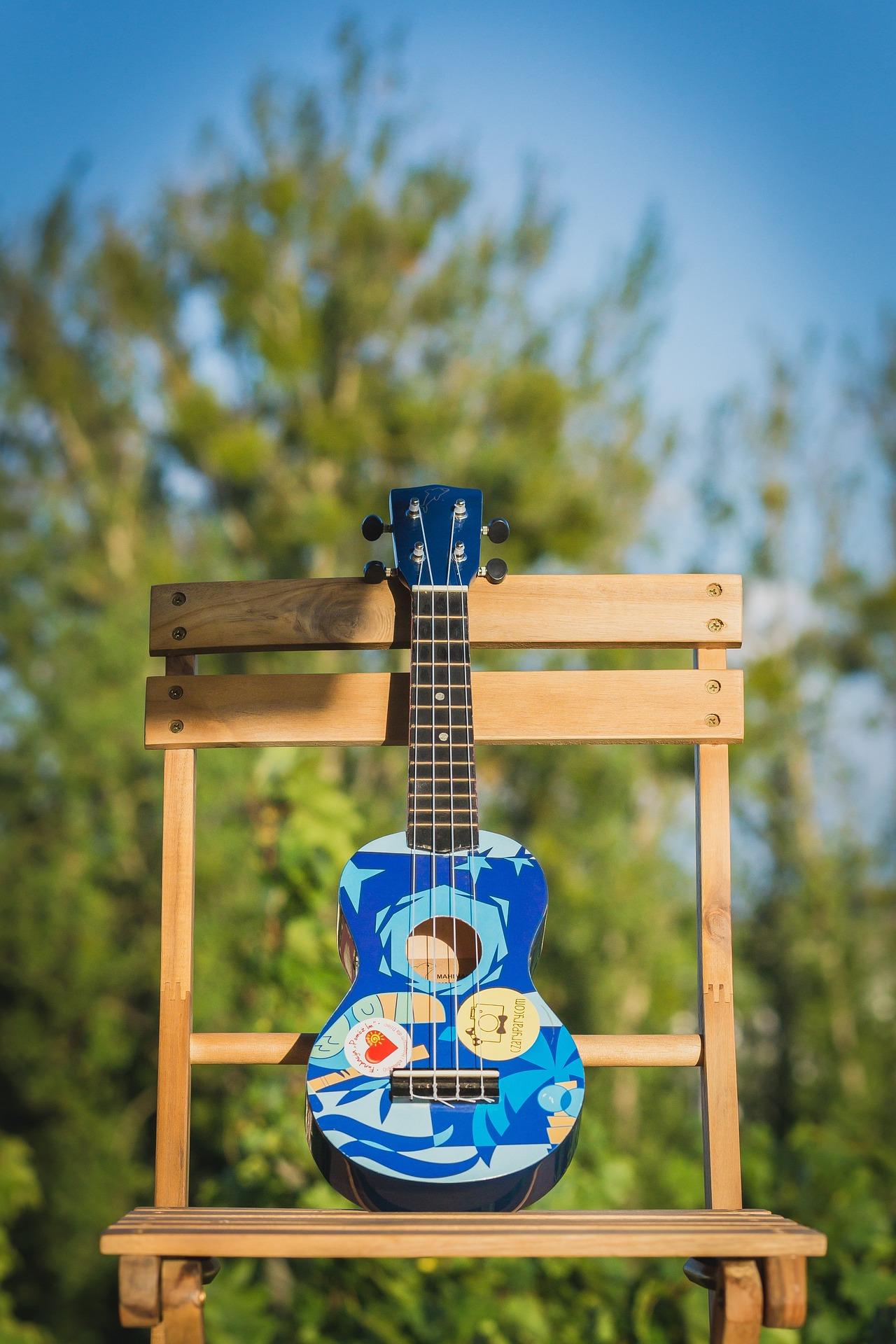 Cavaquinho colorido em tons de azul sobre uma cadeira de madeira.