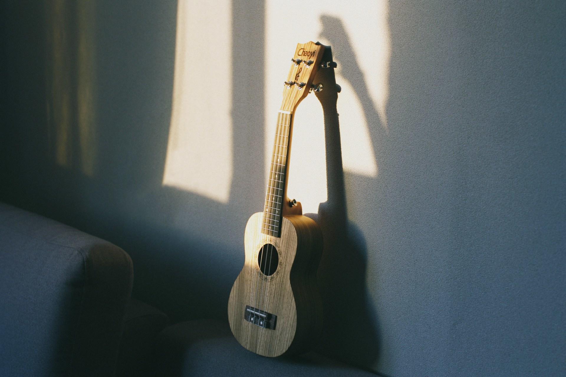 Foto de um cavaquinho escorado em uma parede.