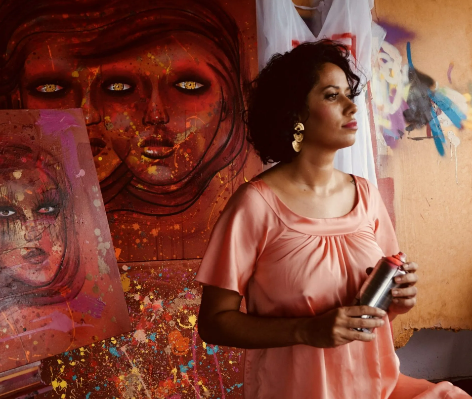 Fotografia de Panmela Castro em frente a sua obra de grafite