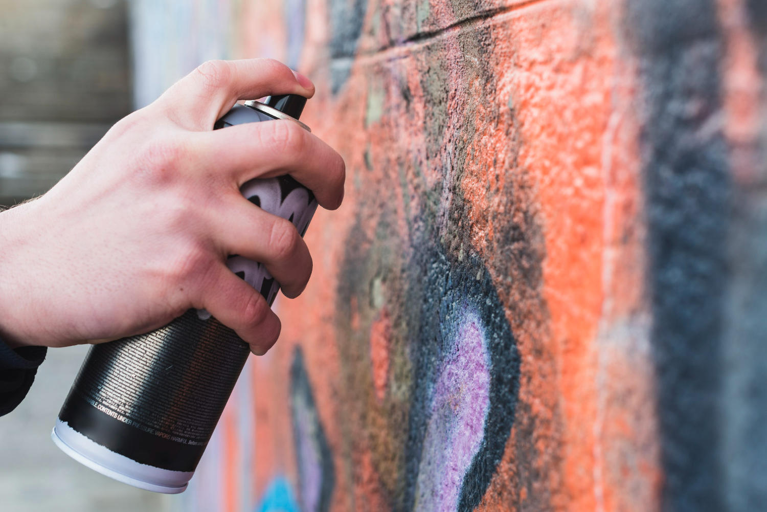Fotografia de mão segurando lata de spray para grafite