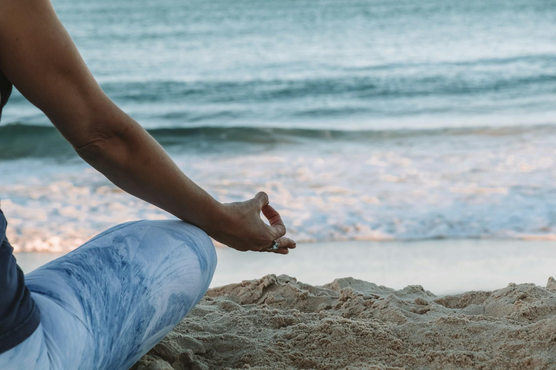 Mulher meditando em uma praia.