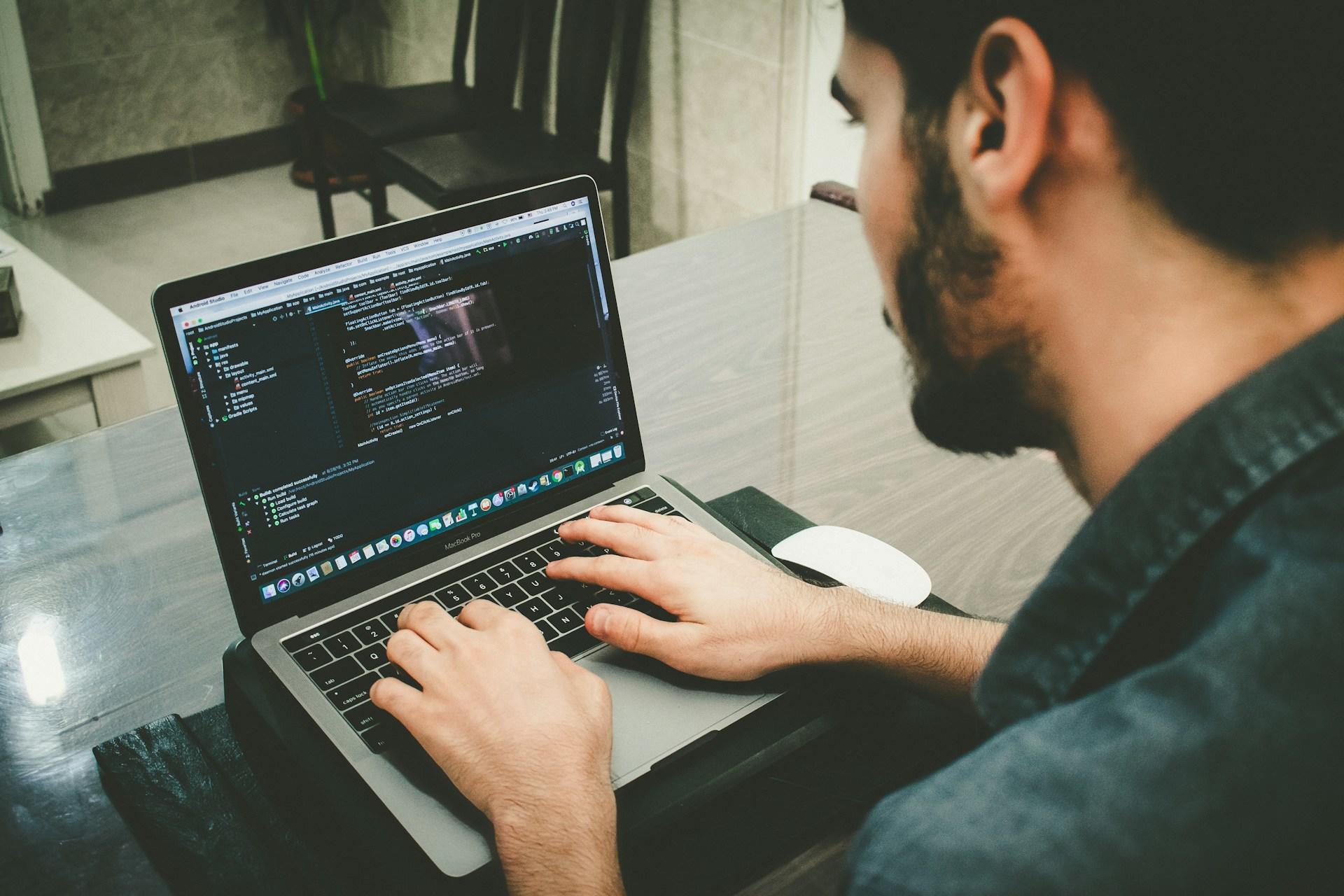 Homem usando um notebook para programar em Python