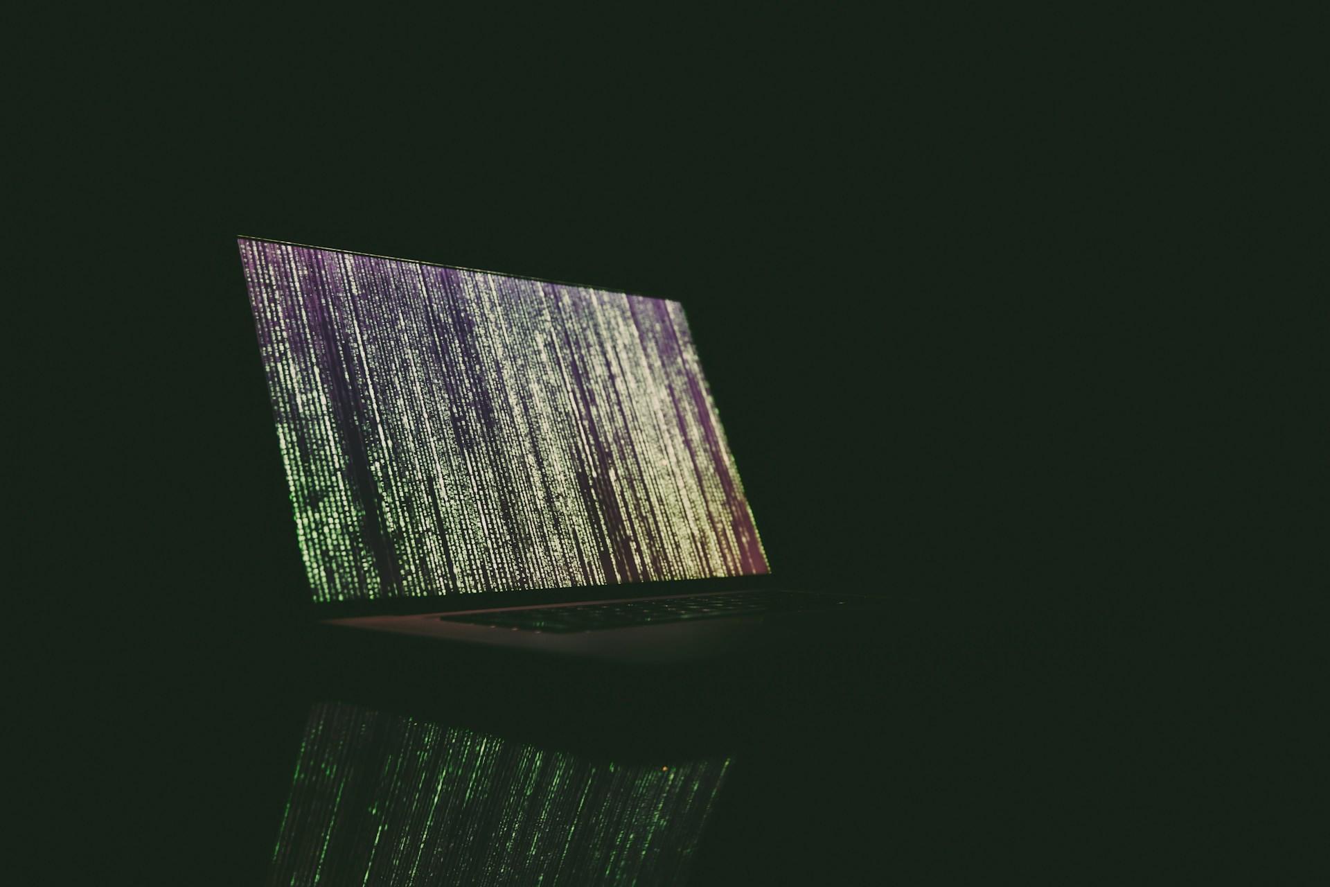 Fundo escuro com notebook programando