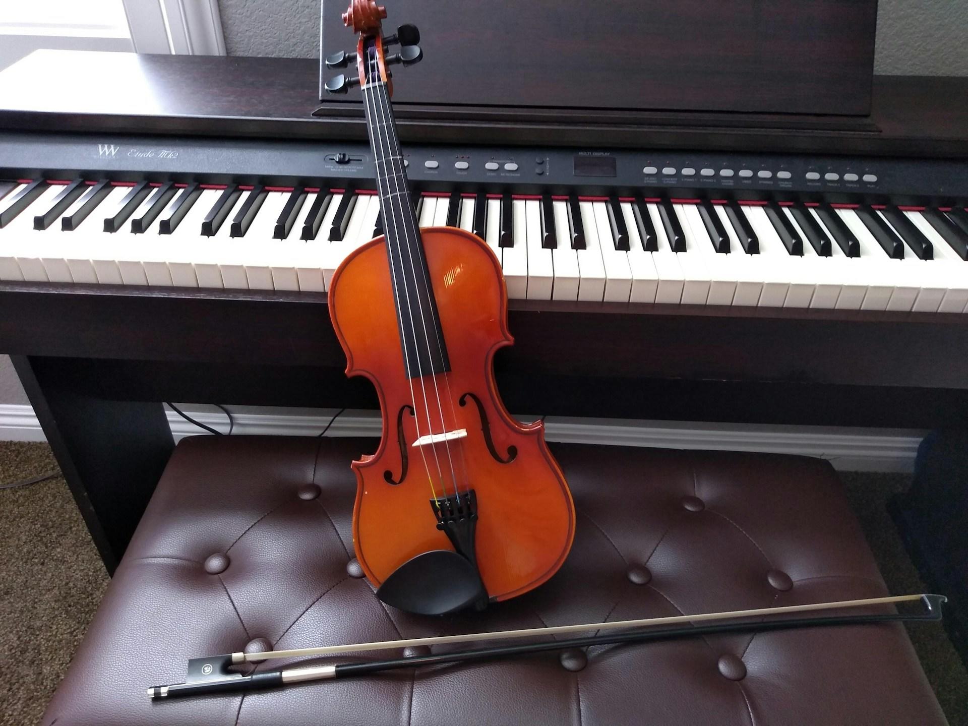 Fotografia de violino em frente a um piano