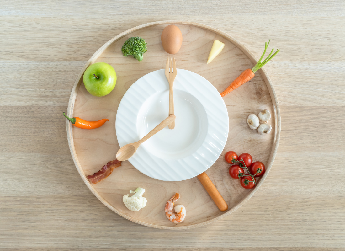 Prato com talheres simbolizando horas e alimentos saudáveis