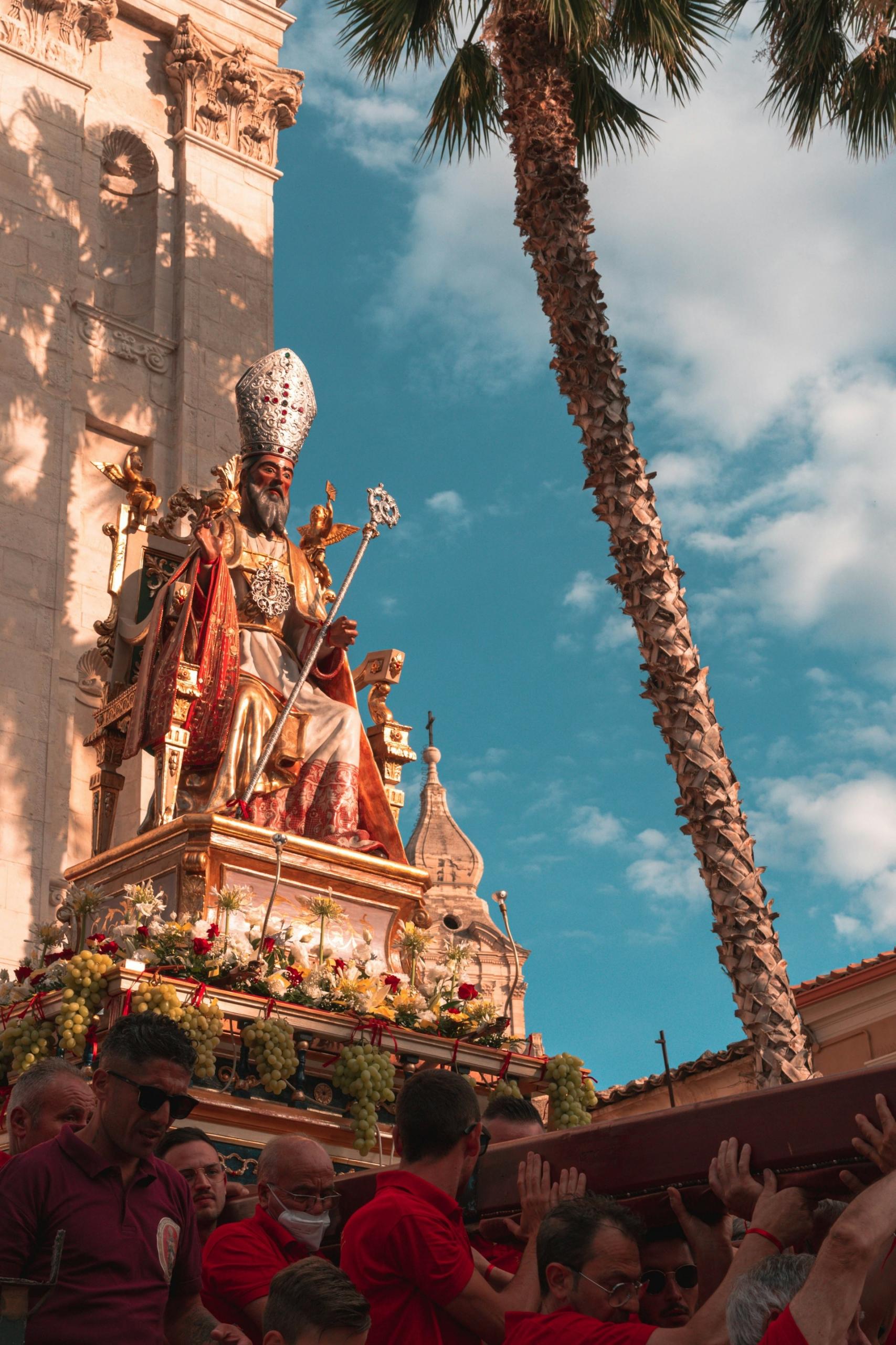Imagem de homens a carregar uma imagem de um santo na Sicília, Itália.