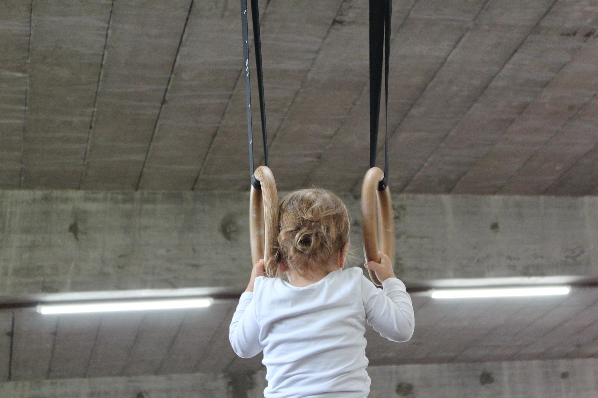 Criança segurando duas argolas.