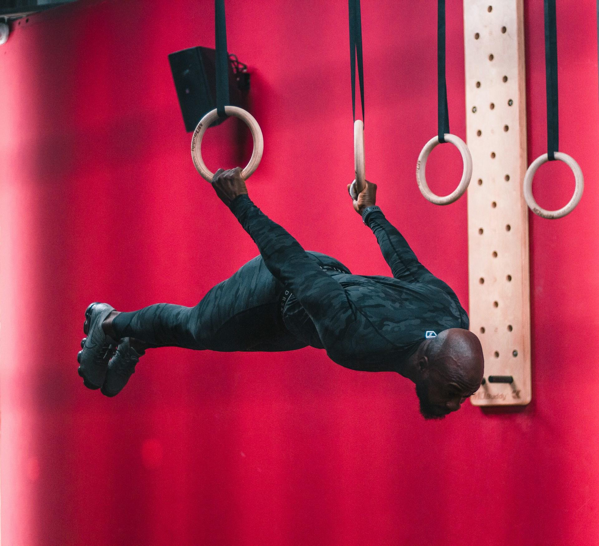 Homem praticando ginástica nas argolas.