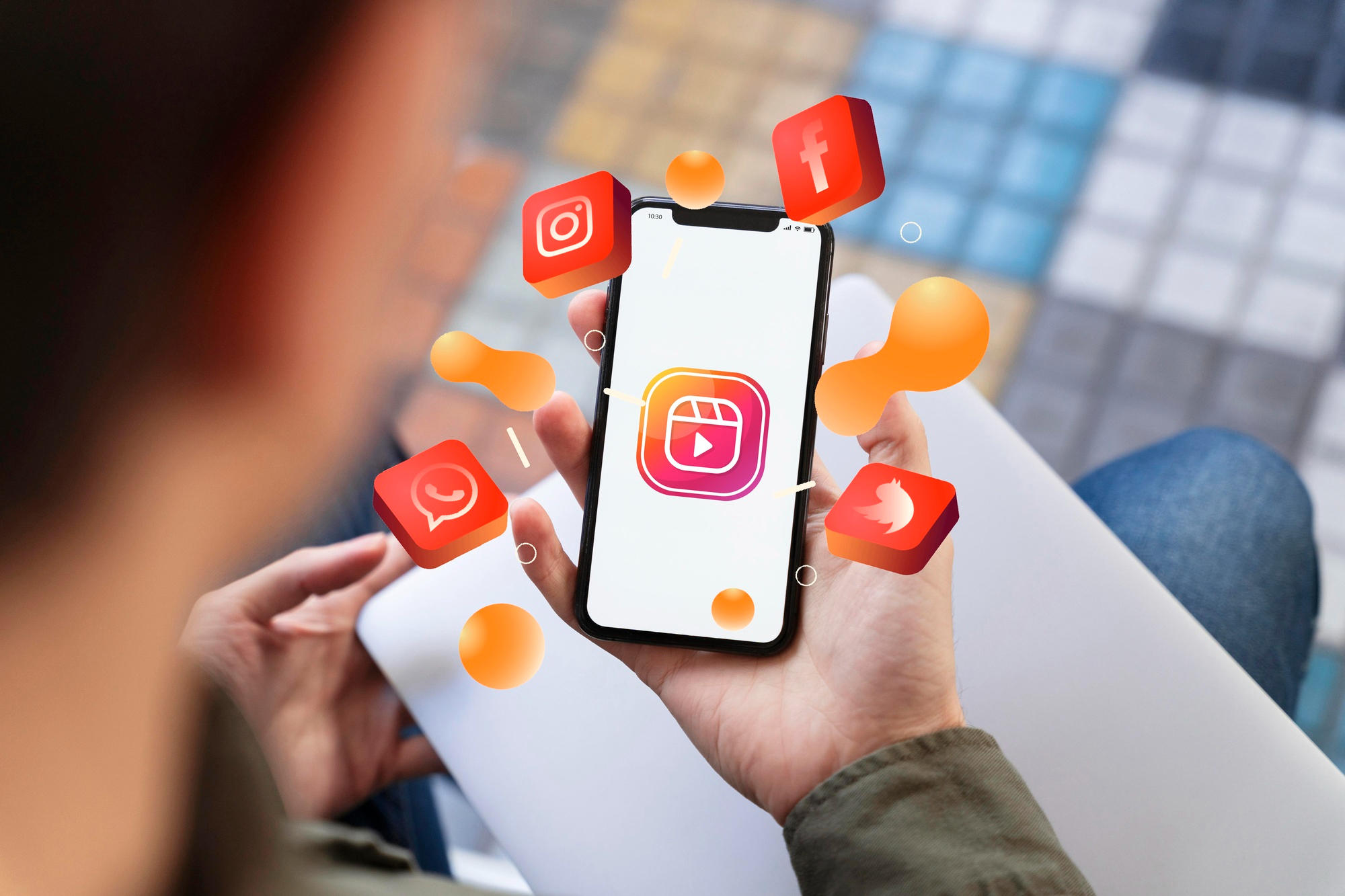Pessoa mexendo no celular com os emojis do Instagram, Facebook, Whatsapp e Twitter. 