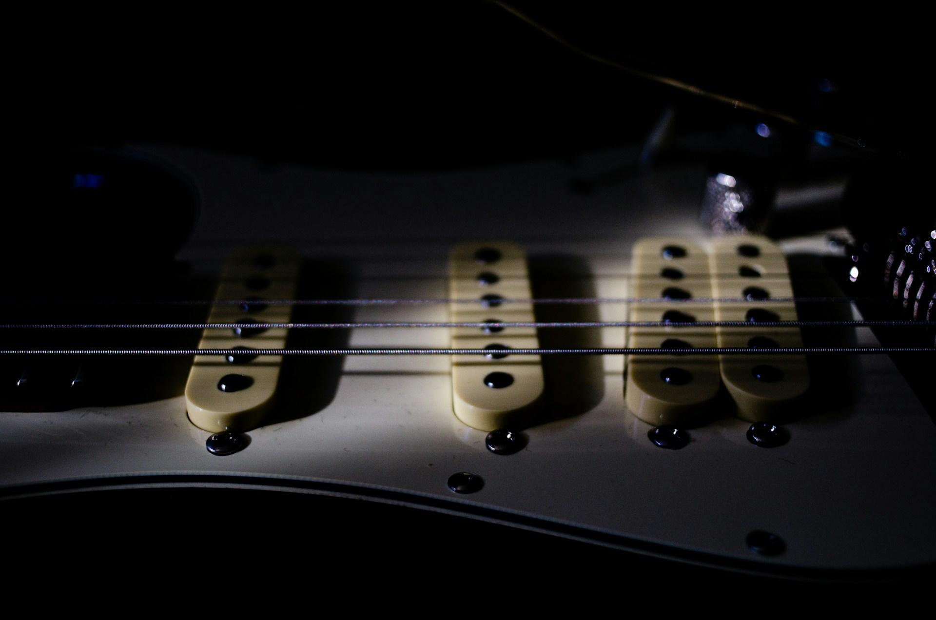 Fotografia de guitarra deitada a meia luz