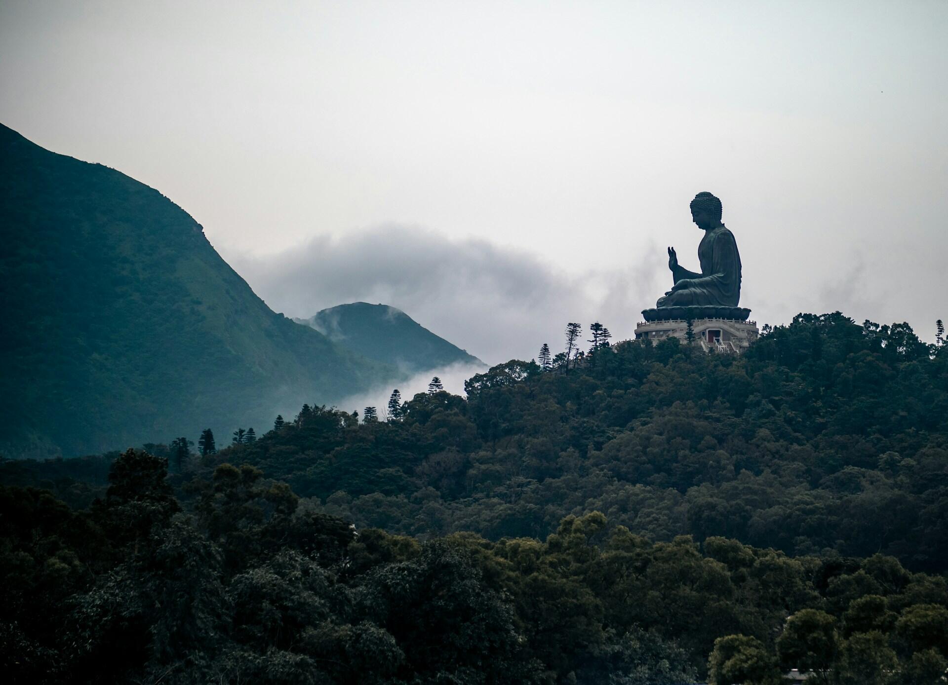 Imagem de um Buda no alto de uma montanha.