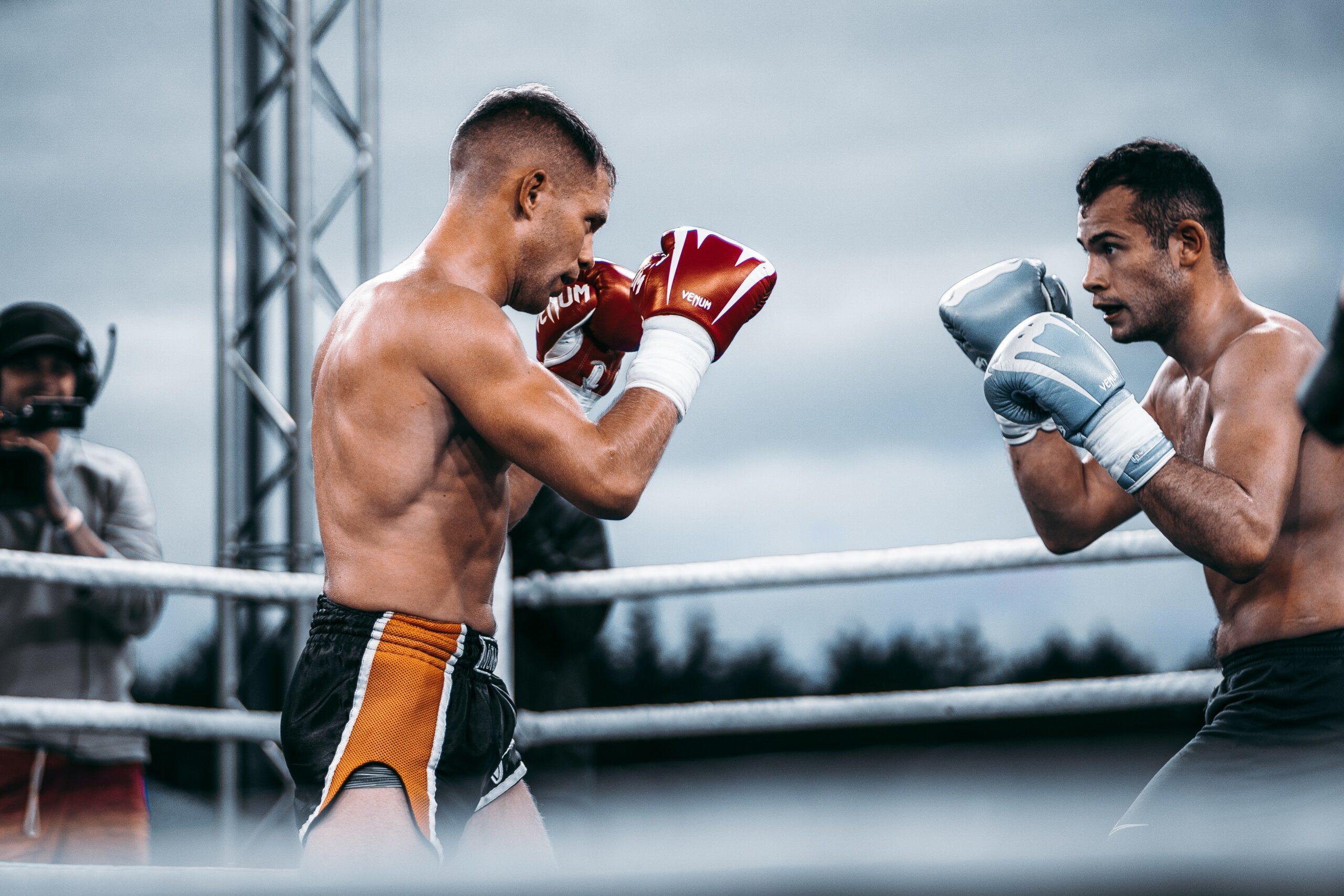 Dois homens de frente com o outro praticando muay thai