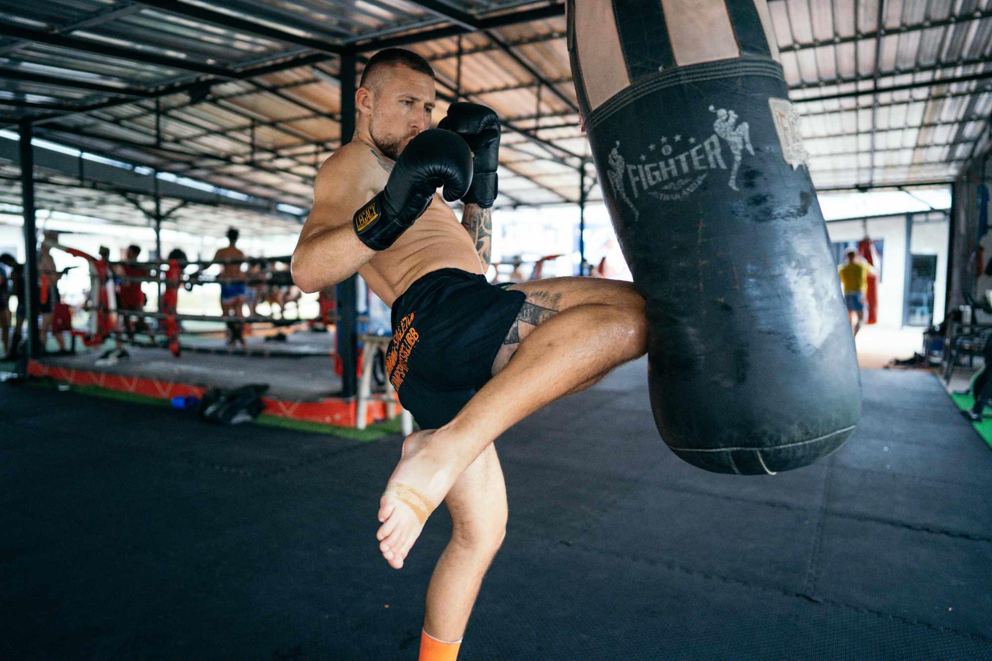 Homem treinando após aprender sobre Muay Thai origem Regras do Muay Thai Muay Thai benefícios Muay Thai características