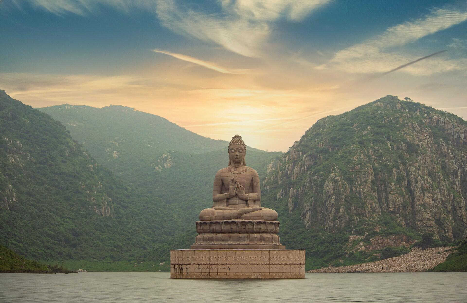 Imagem de uma escultura de Buda em um lago.