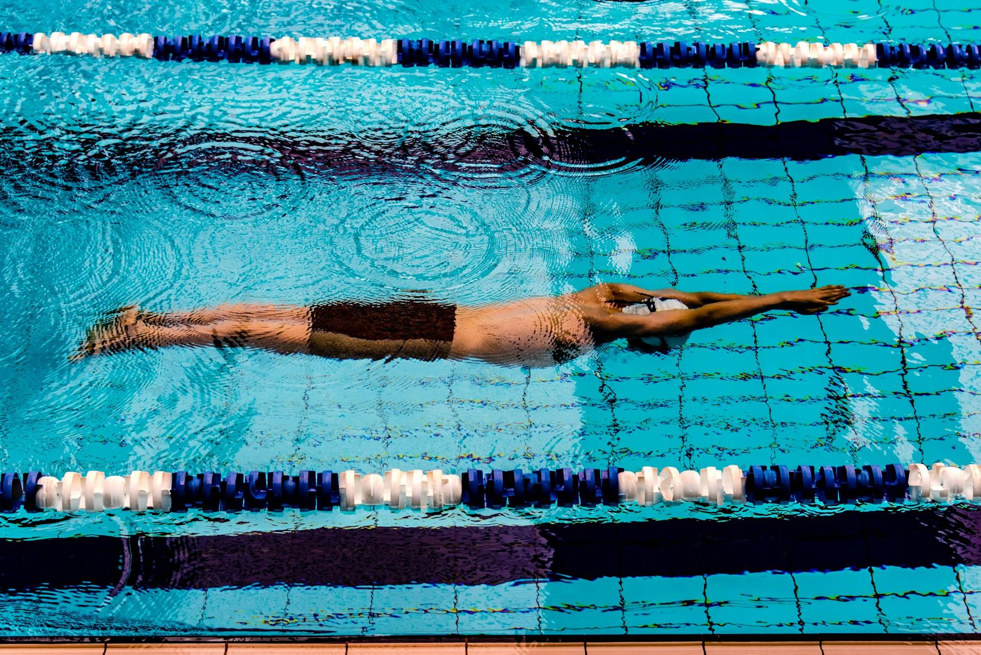 Pessoa nadando em piscina profissional de natação