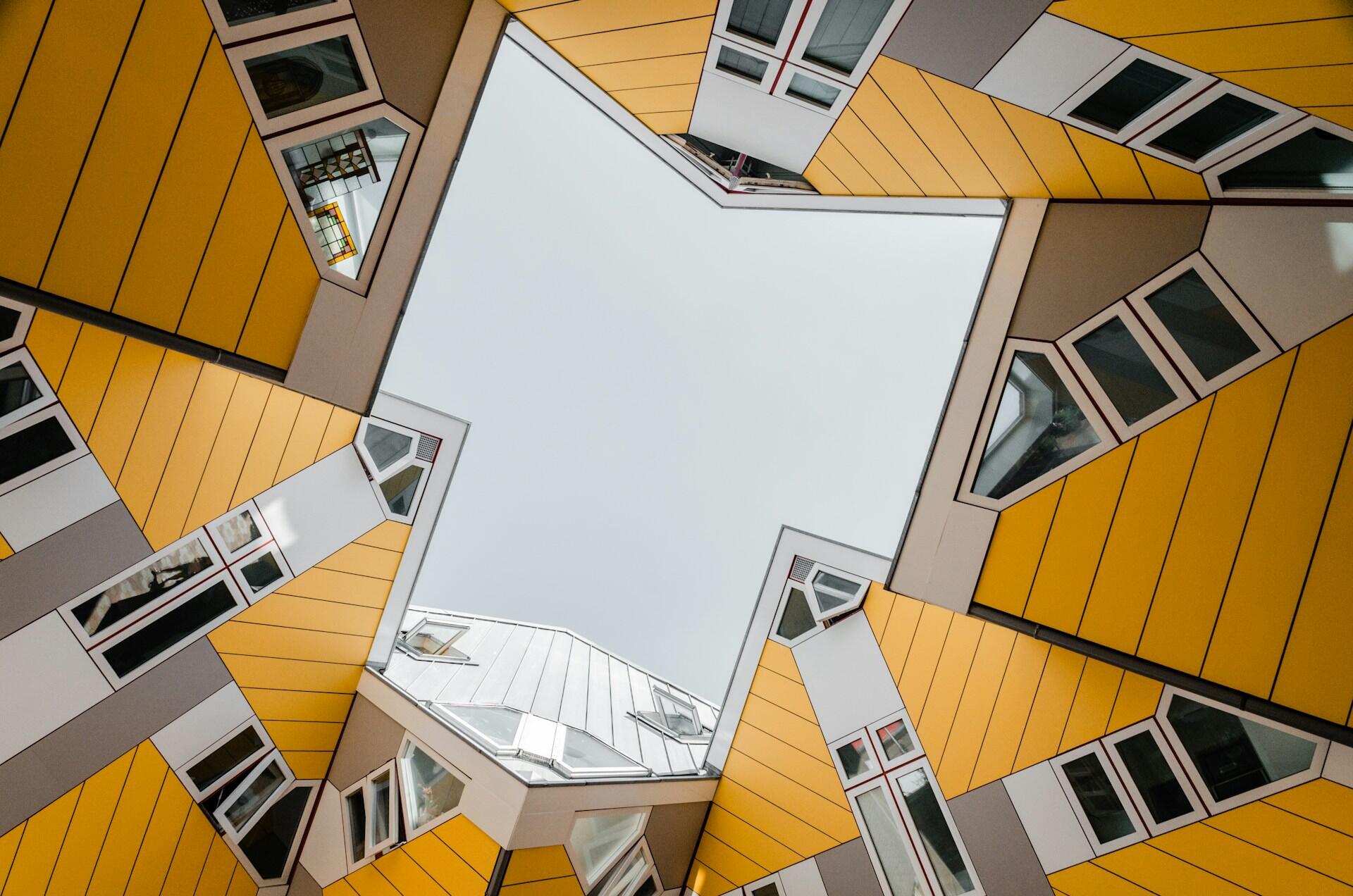 Fotos de baixo para cima de vários prédios em amarelo com arquitetura destacada