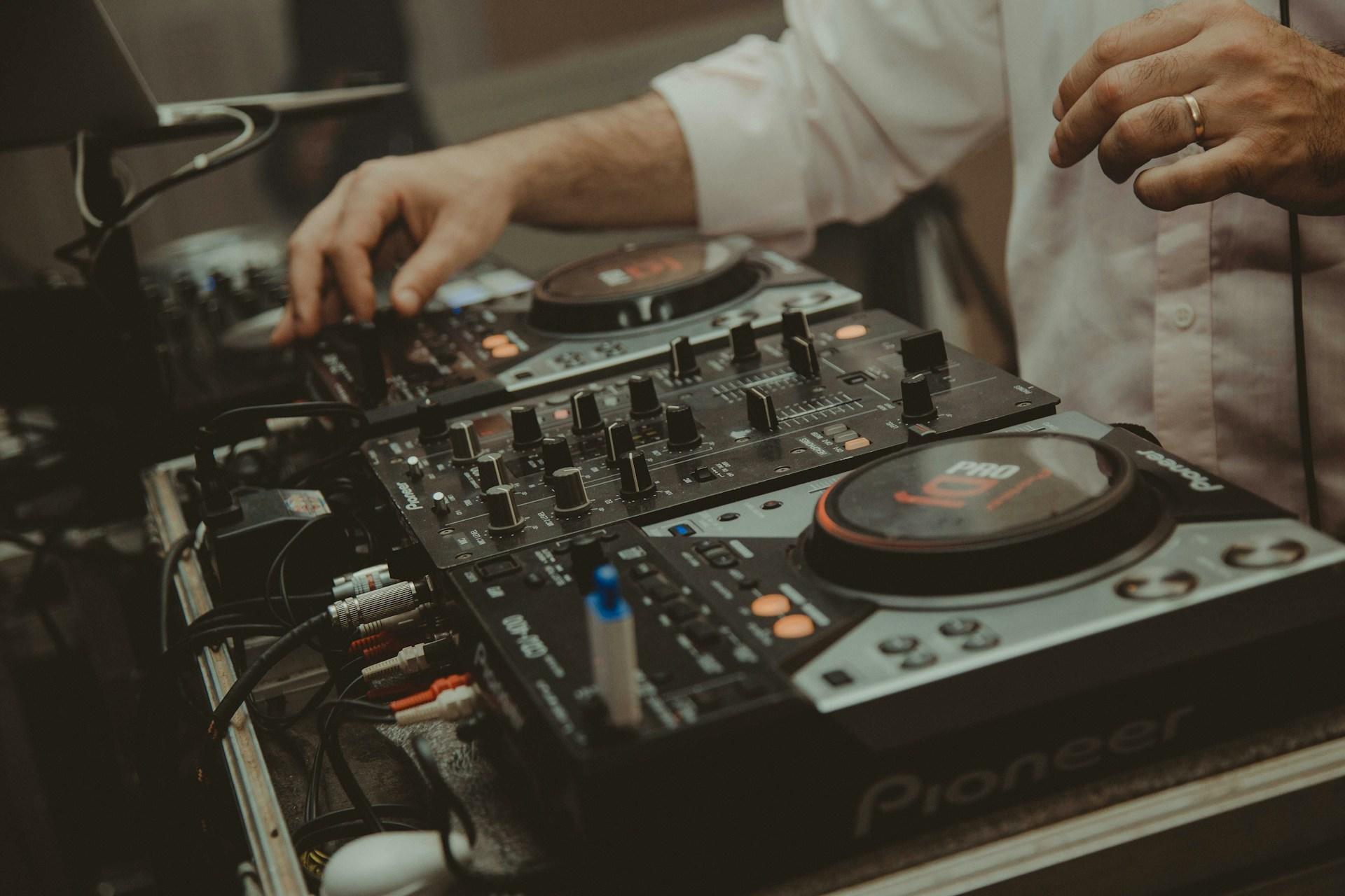 Homem usando uma controladora de DJ da Pionner.