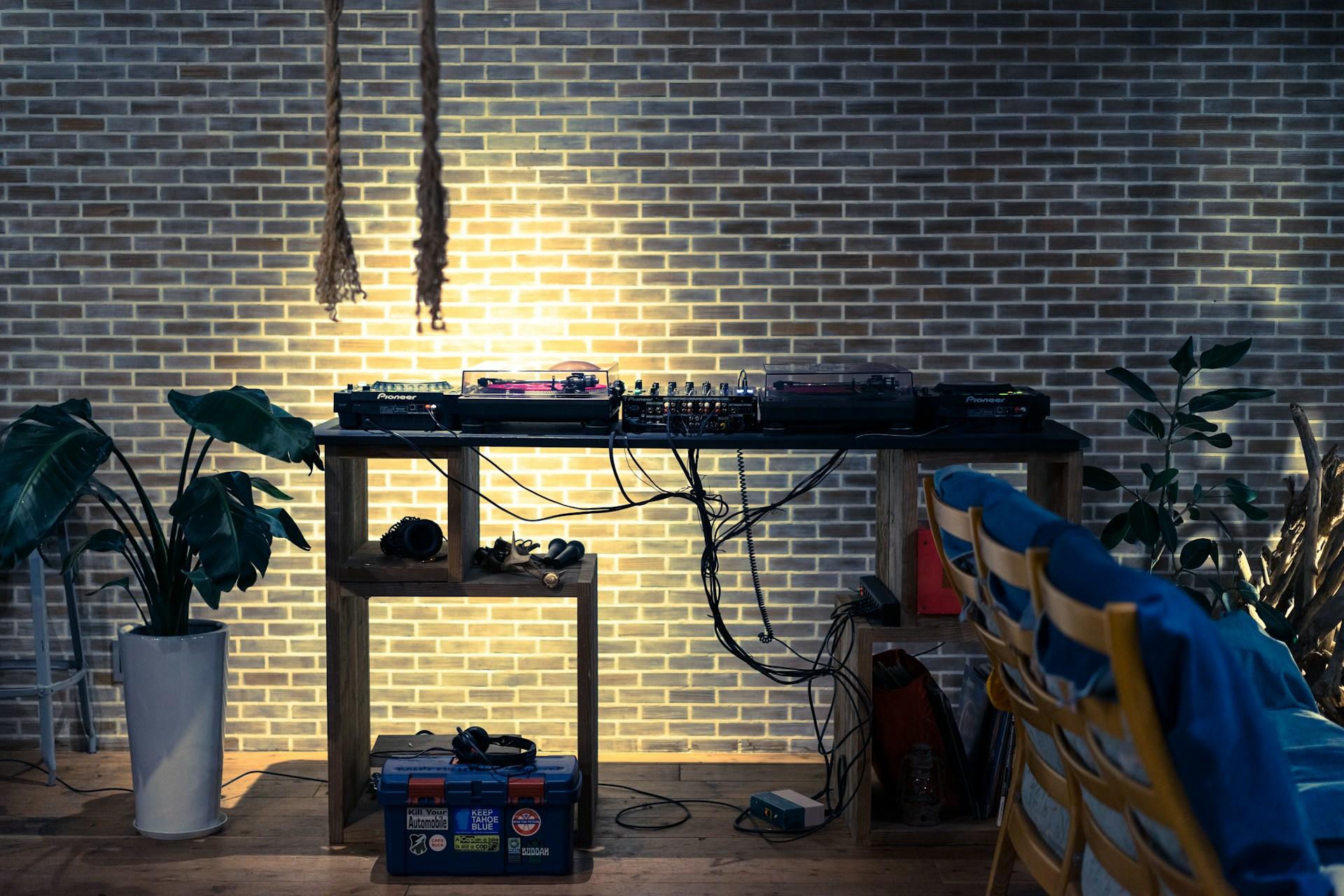 Mesa de DJ em frente a uma parede de tijolos.