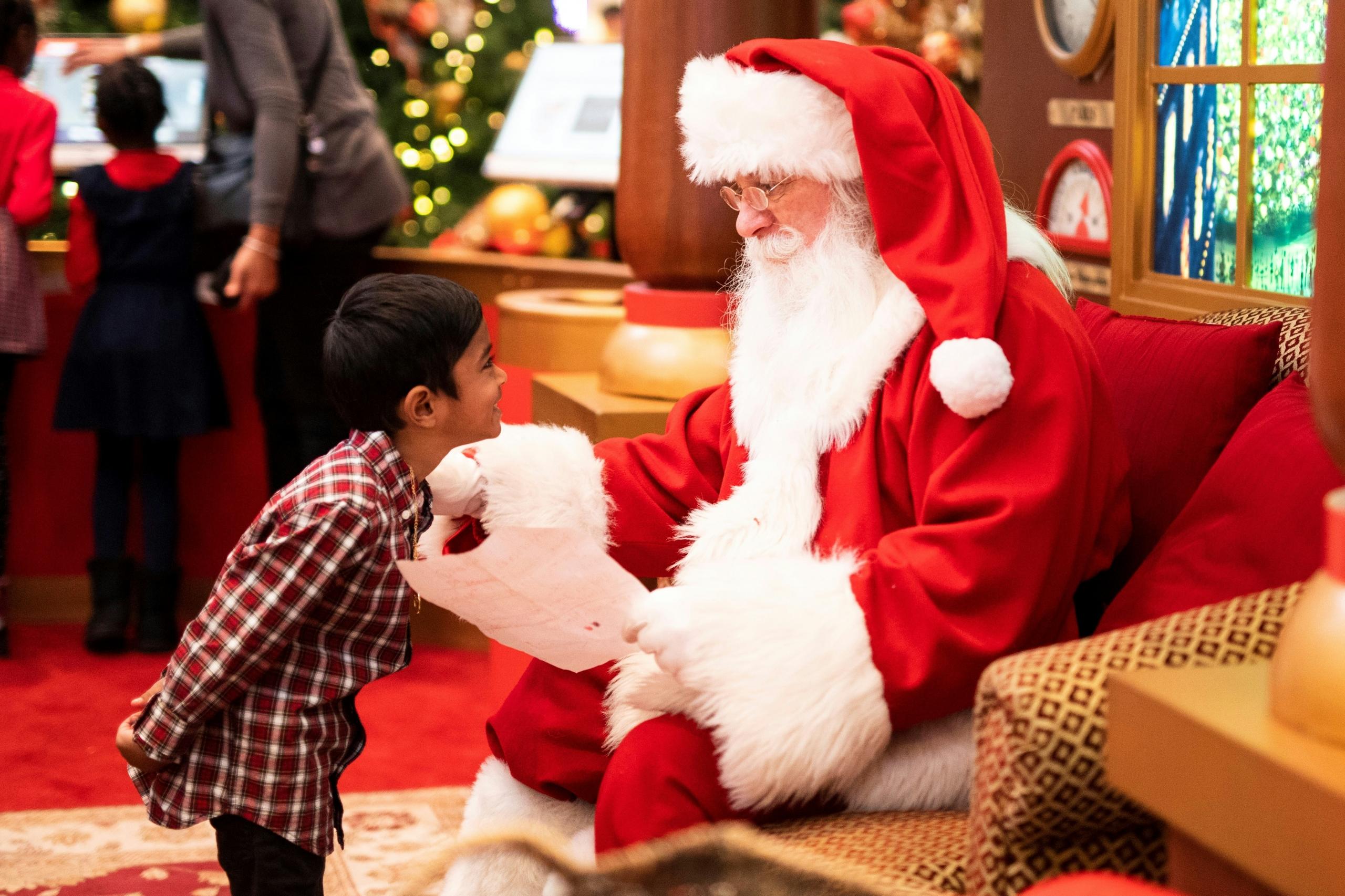 Papai Noel dando prenda para criança.