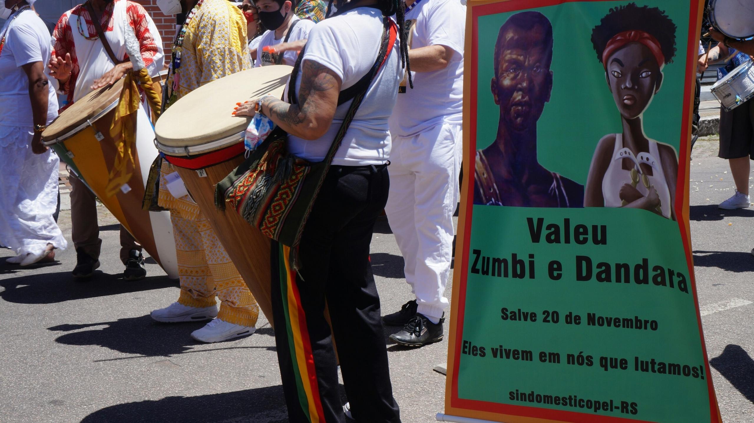 Protesto nas ruas do Brasil, com tambores e faixas.