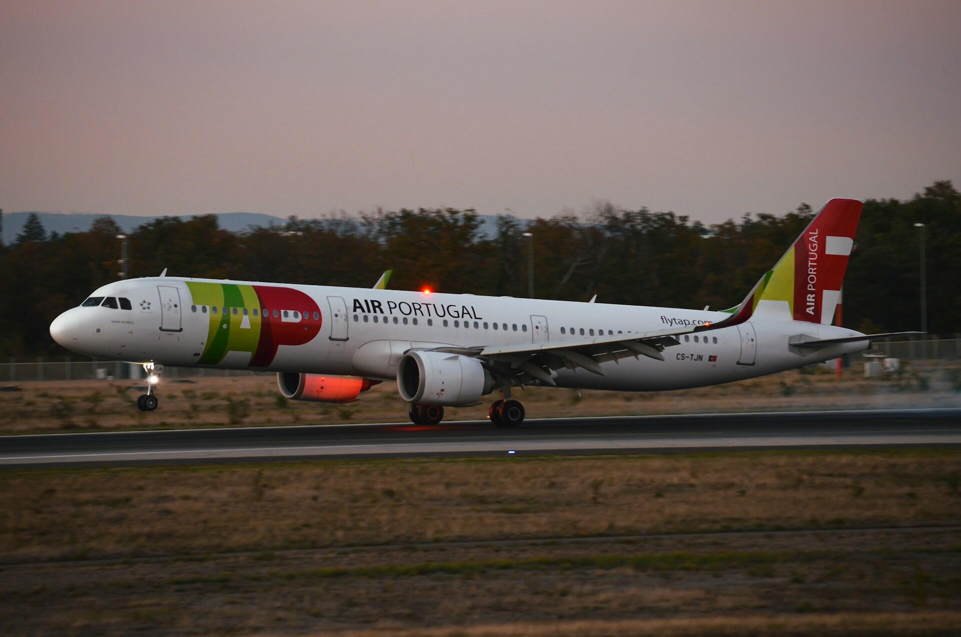Avião da TAP decolando em uma pista de aeroporto.