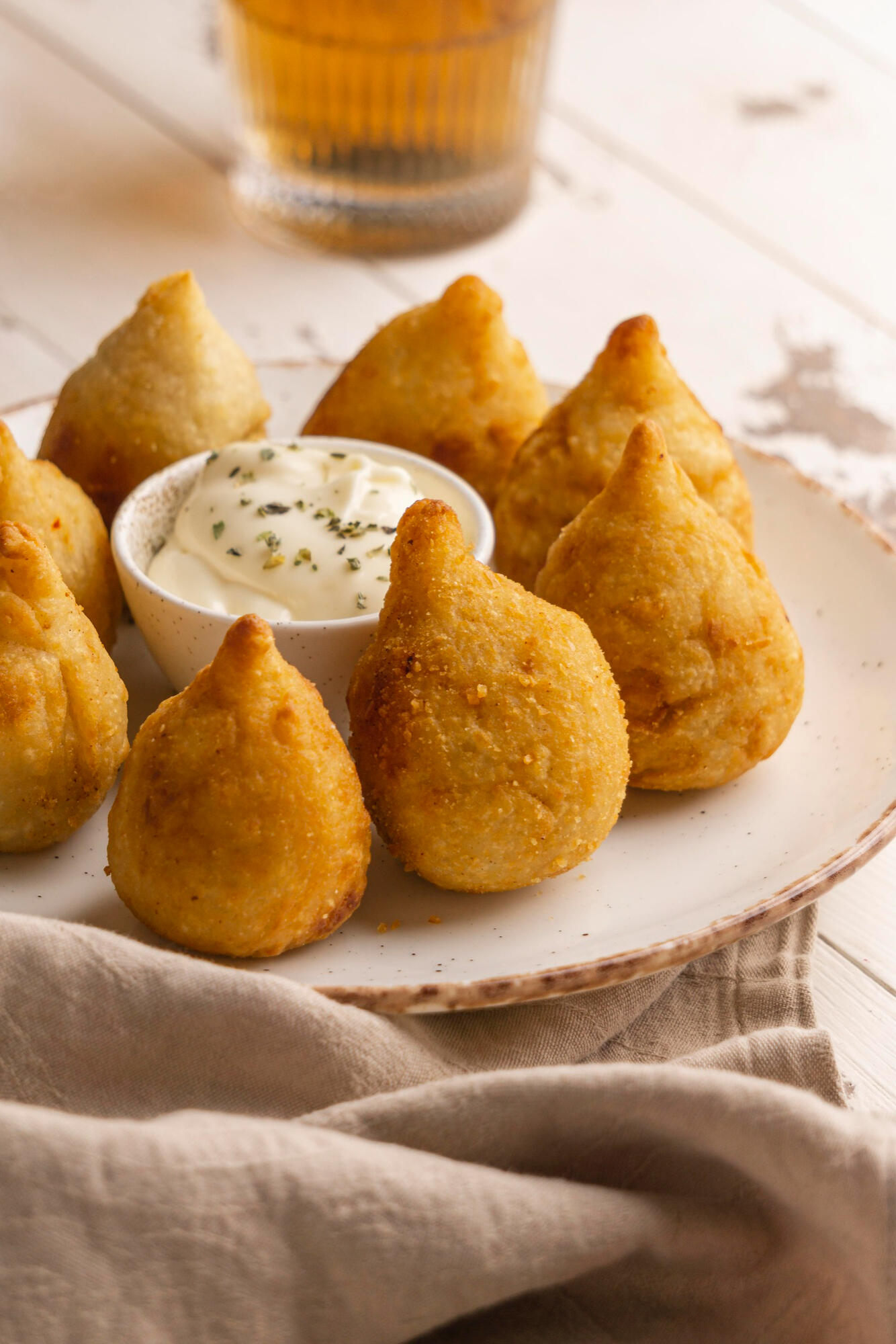 Coxinhas com molho em cima da mesa. 