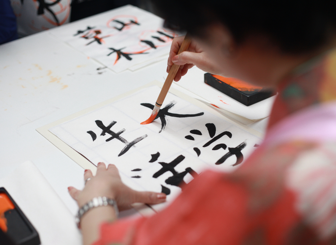 Pessoa escrevendo com um pincel letras em japones