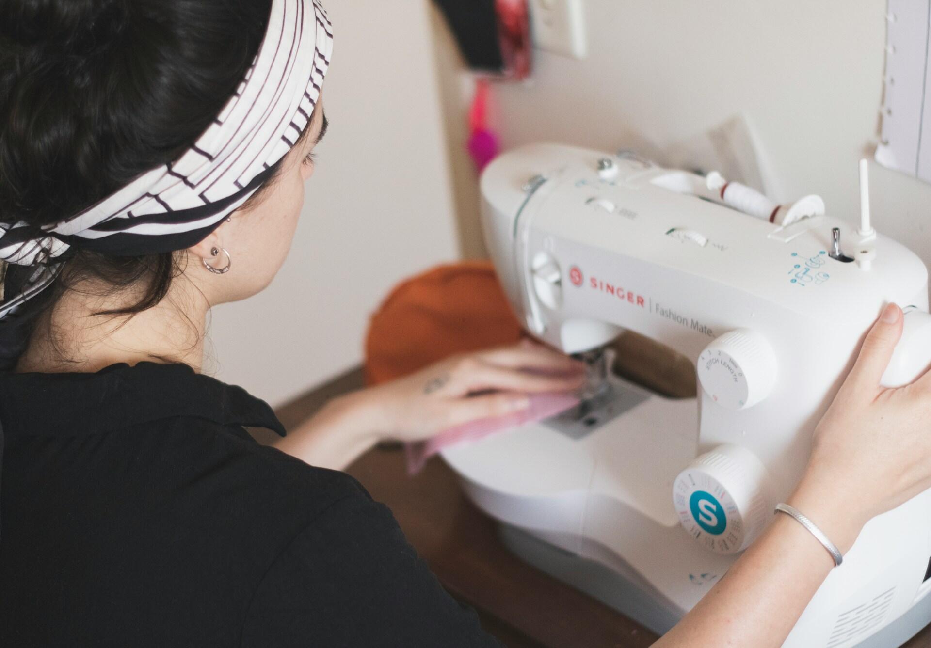 Mulher costurando em uma máquina.