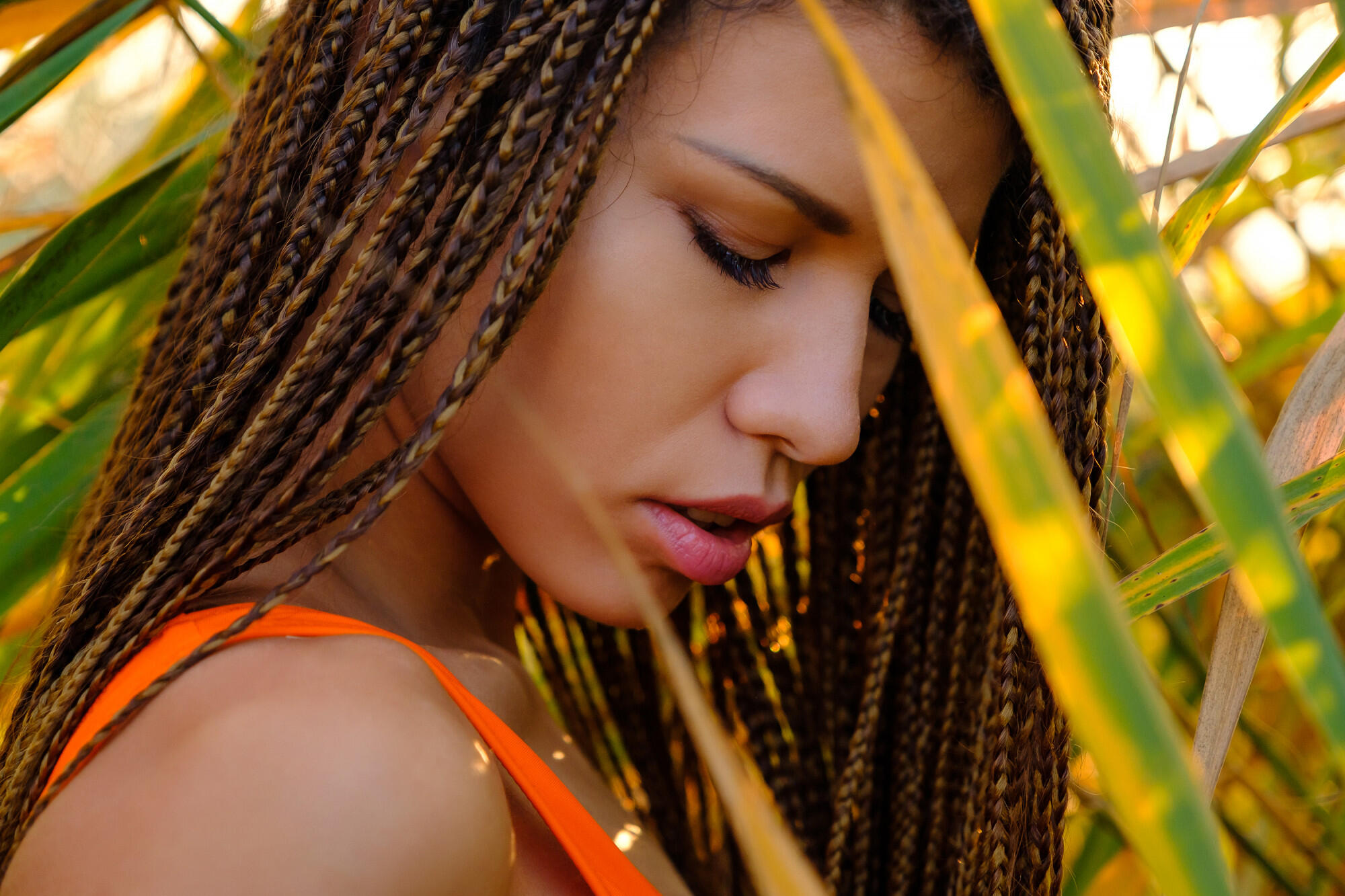 Mulher com tranças no cabelo, entre as plantas.