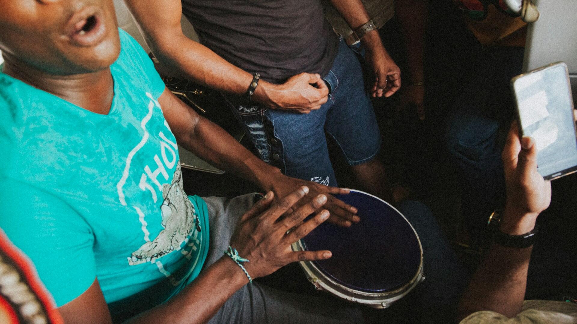 Imagem de pessoas tocando pandeiro.