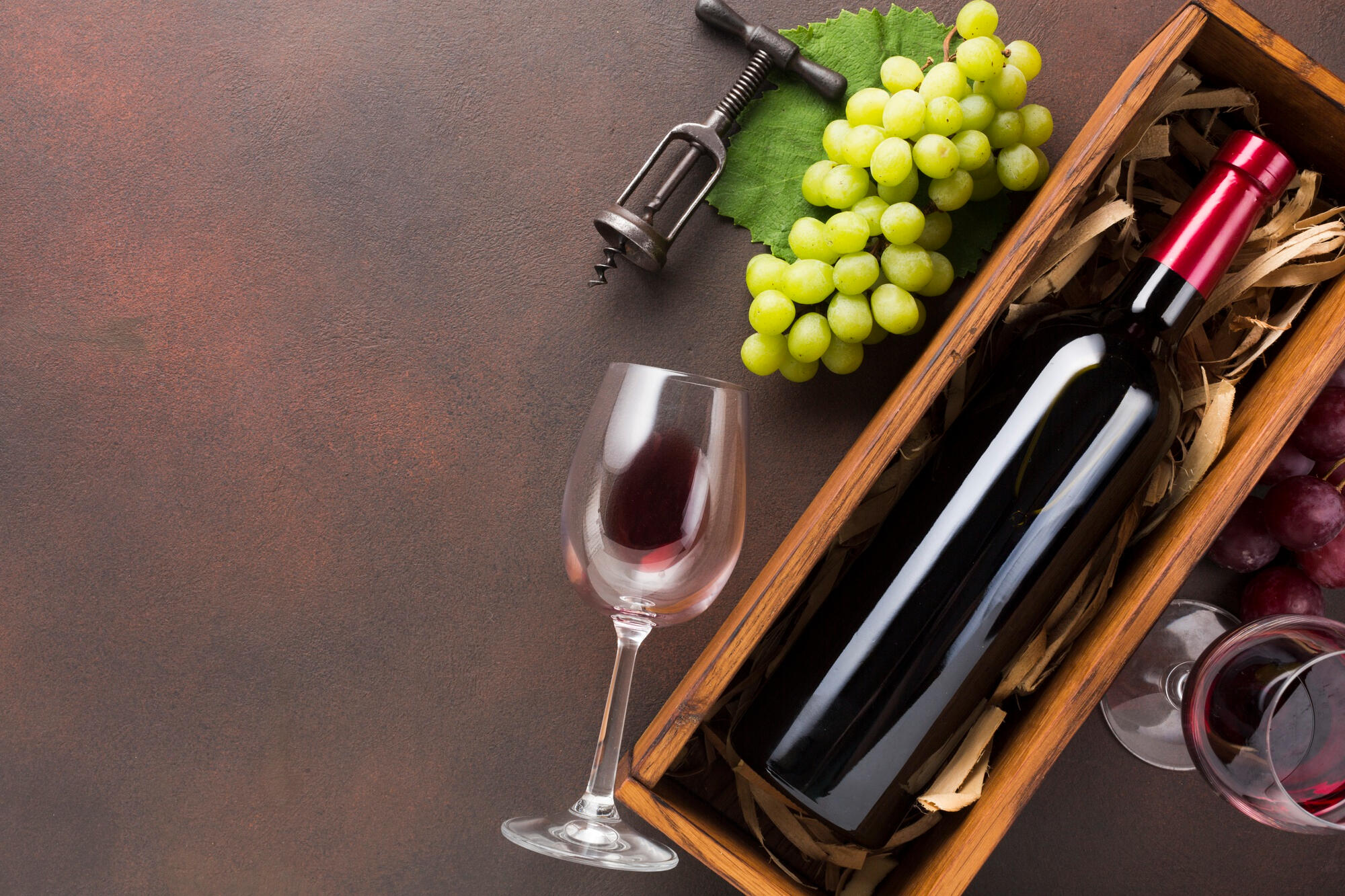 Vinho italiano, uva e taça em cima da mesa.