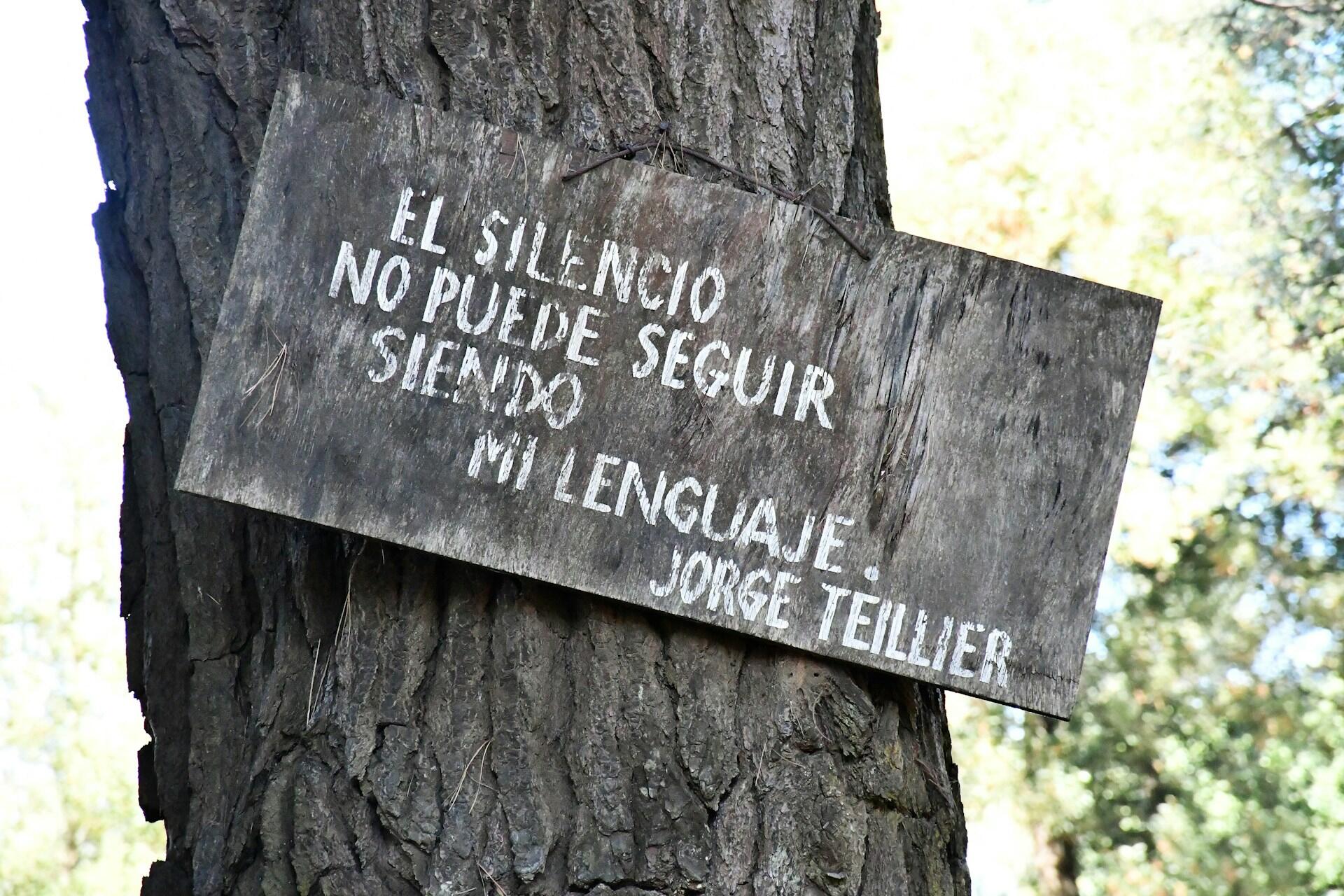 Imagem de uma placa em uma árvore com dizeres em Espanhol.