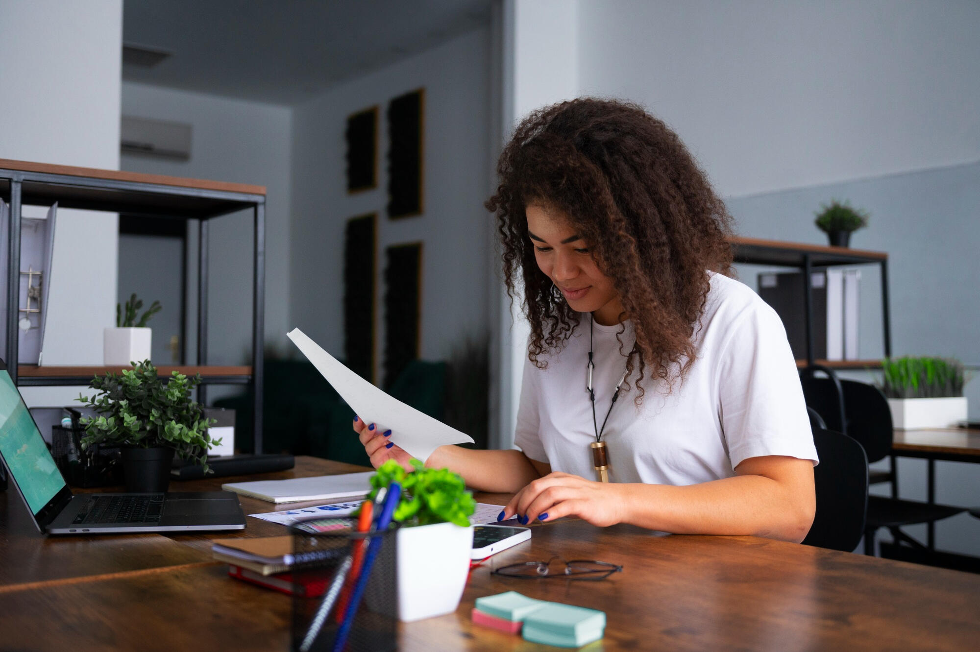 Estudante estudando inglês na mesa com celular, notebook e papeis. 