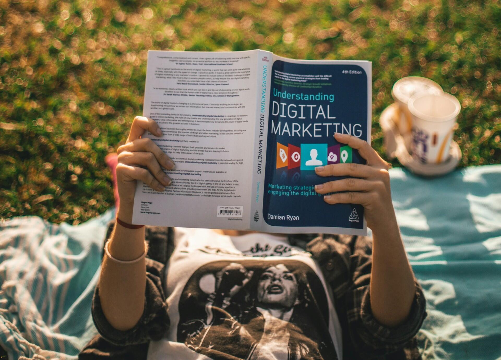 Mulher lendo um livro sobre Marketing Digital
