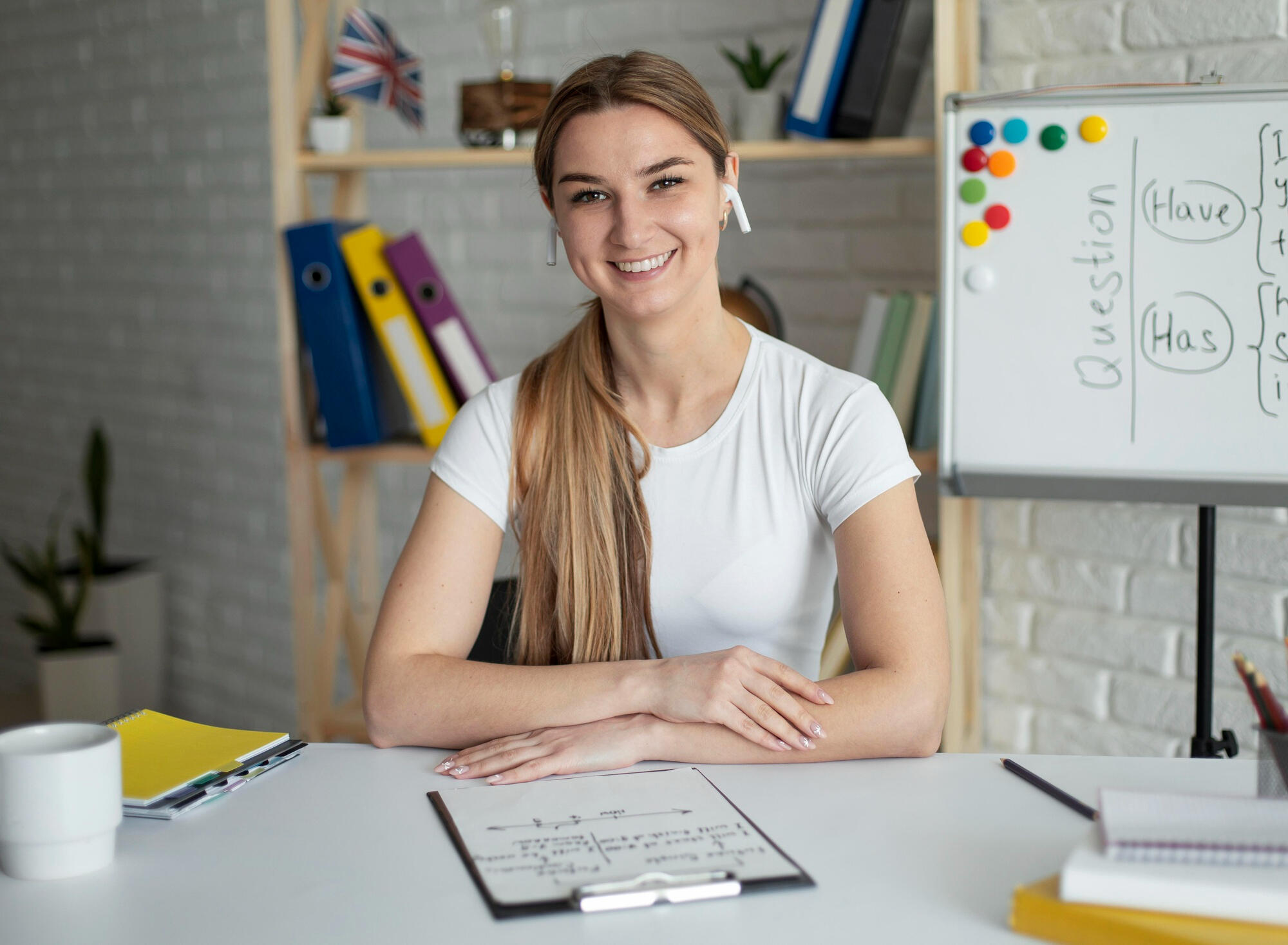 Mullher sentada na mesa com papéis estudando inglês.