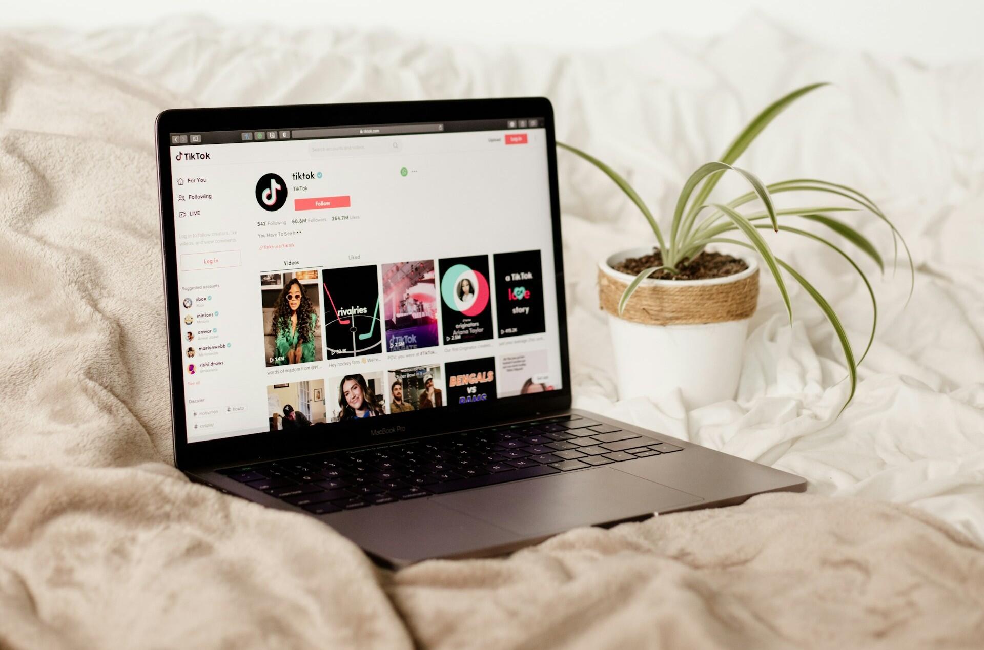 Imagem de um computador em uma cama com o Tiktok na tela.