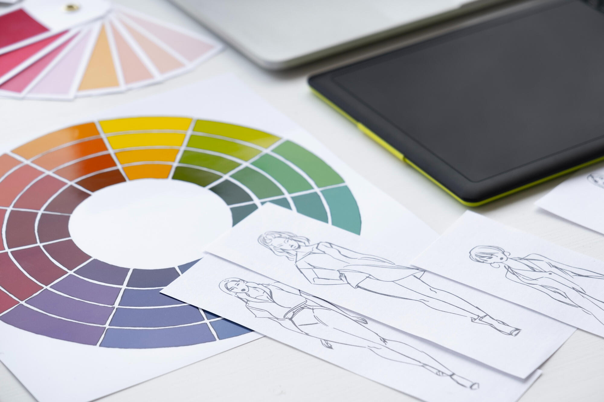 Papéis de paleta de cores e círculos cromáticos em cima da mesa.