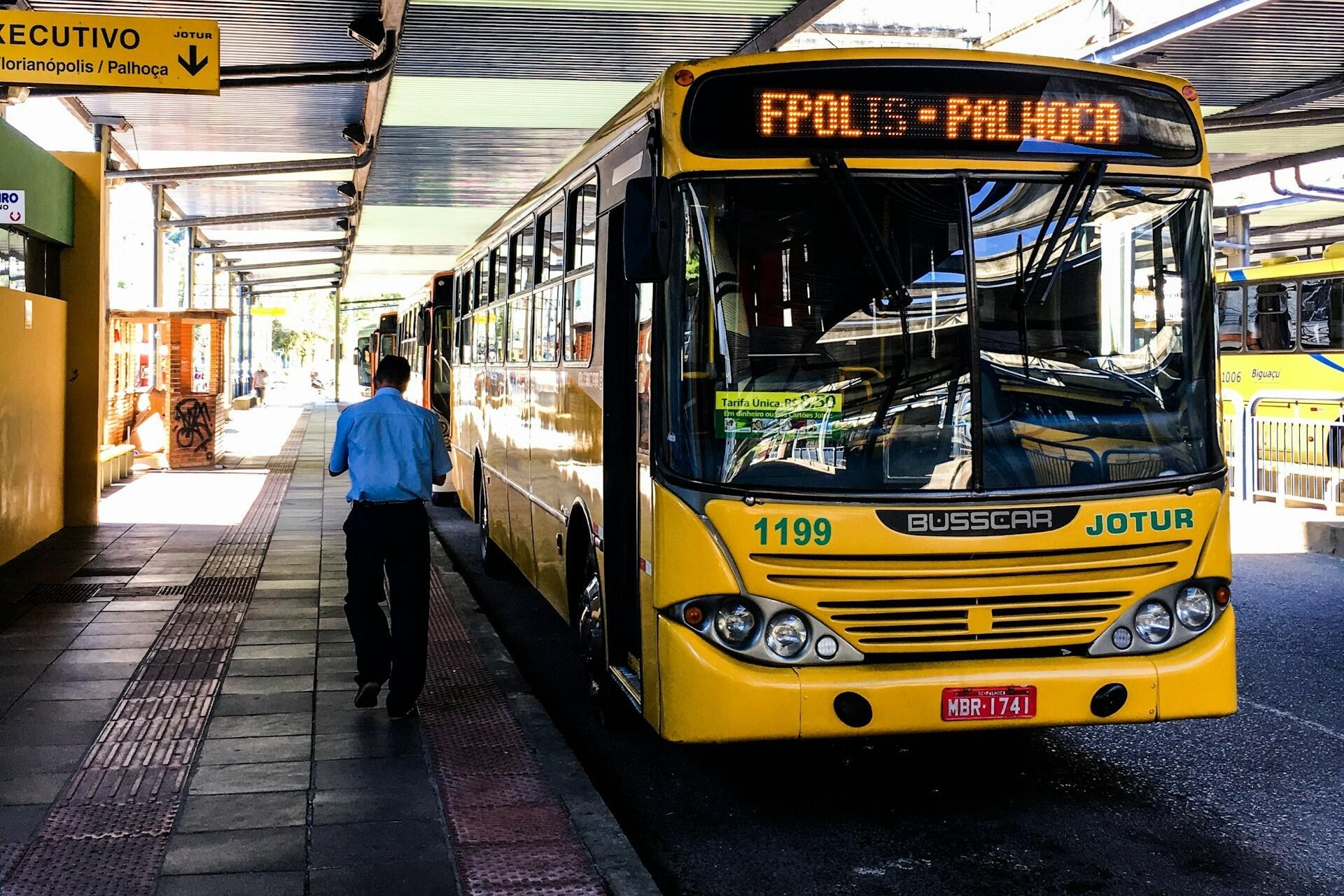 Imagem de um ônibus urbano em uma estação de ônibus.