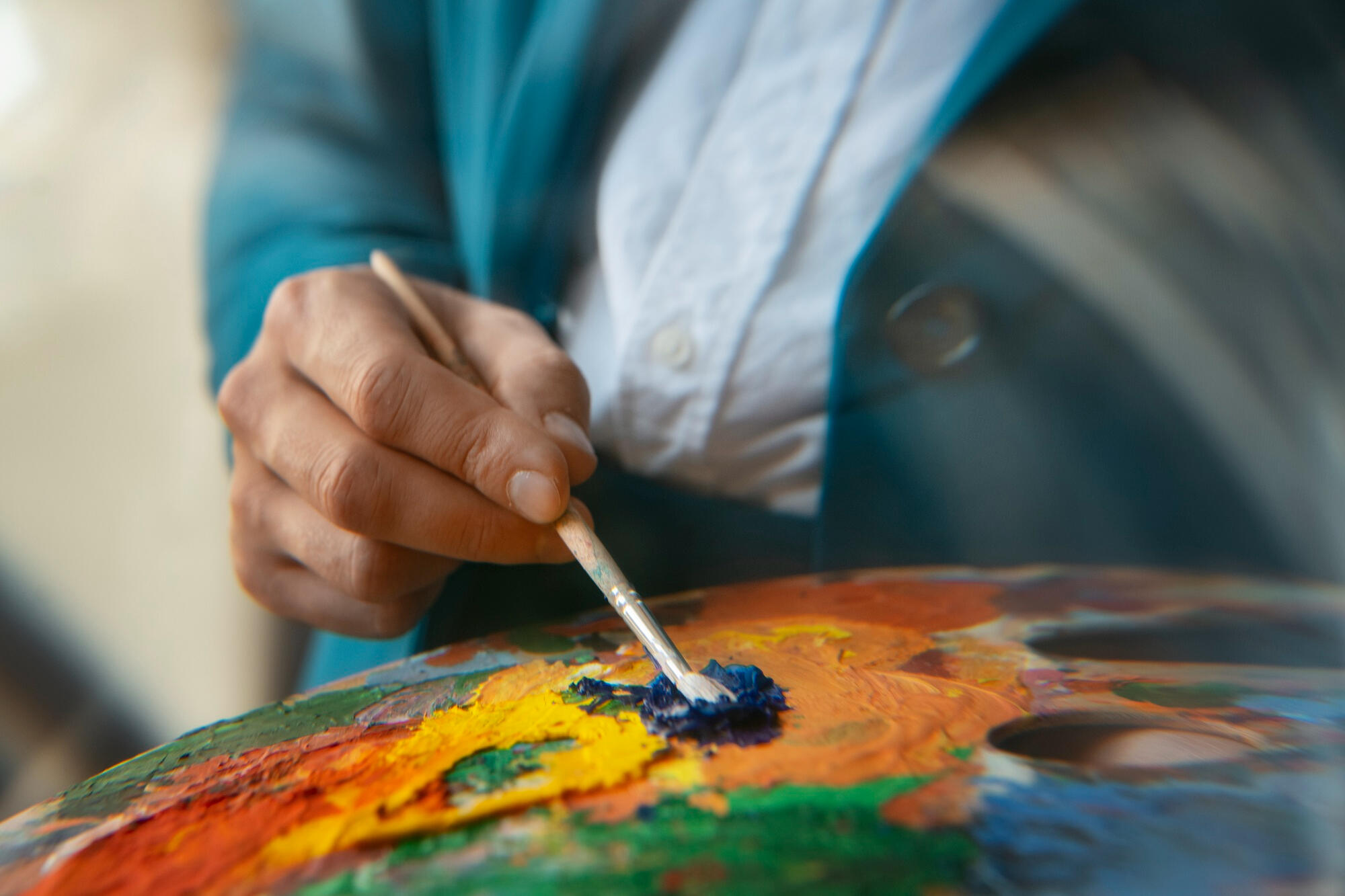 Pintor misturando cores na tela com o pincel. 