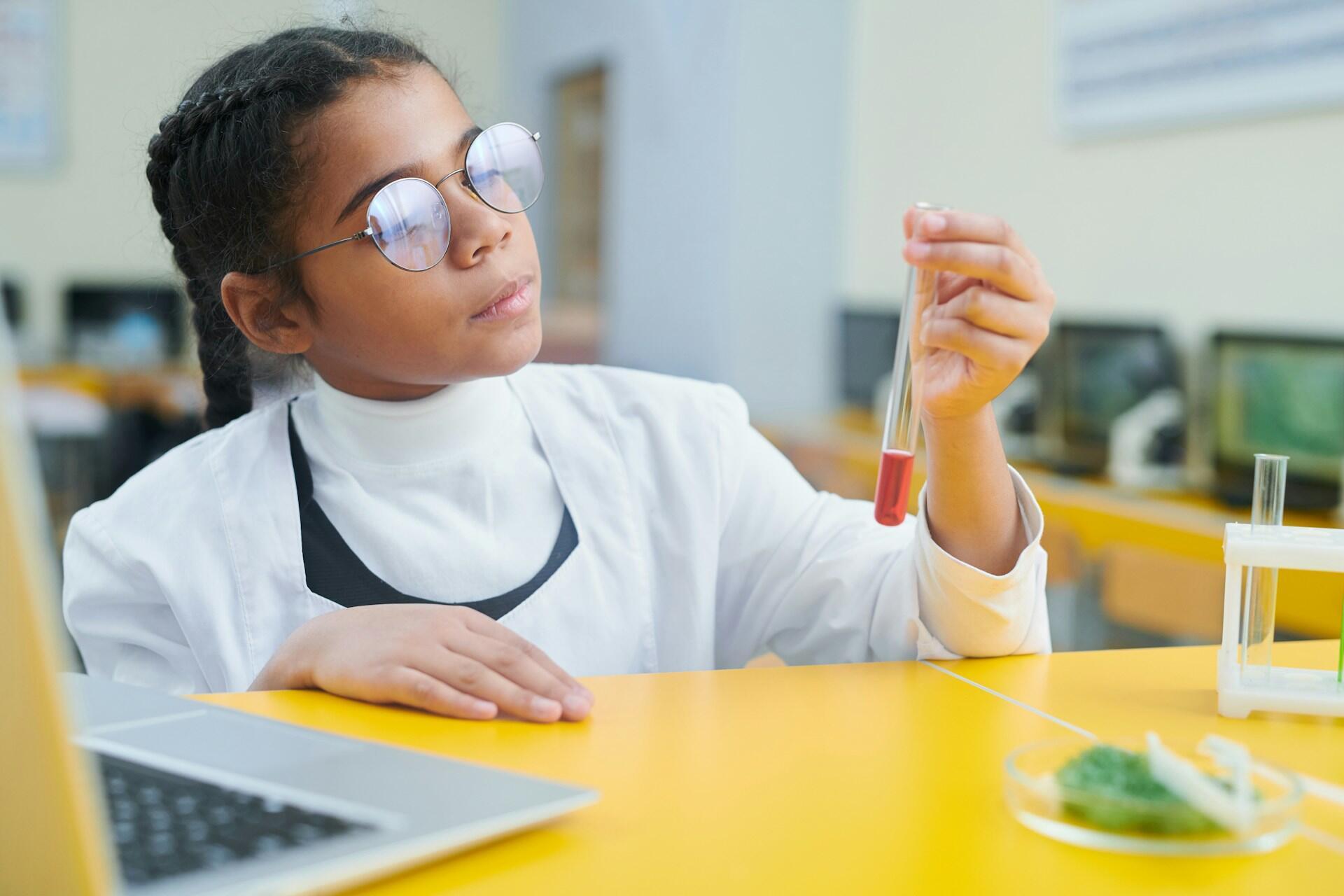 Menina na escola vestida de cientista.