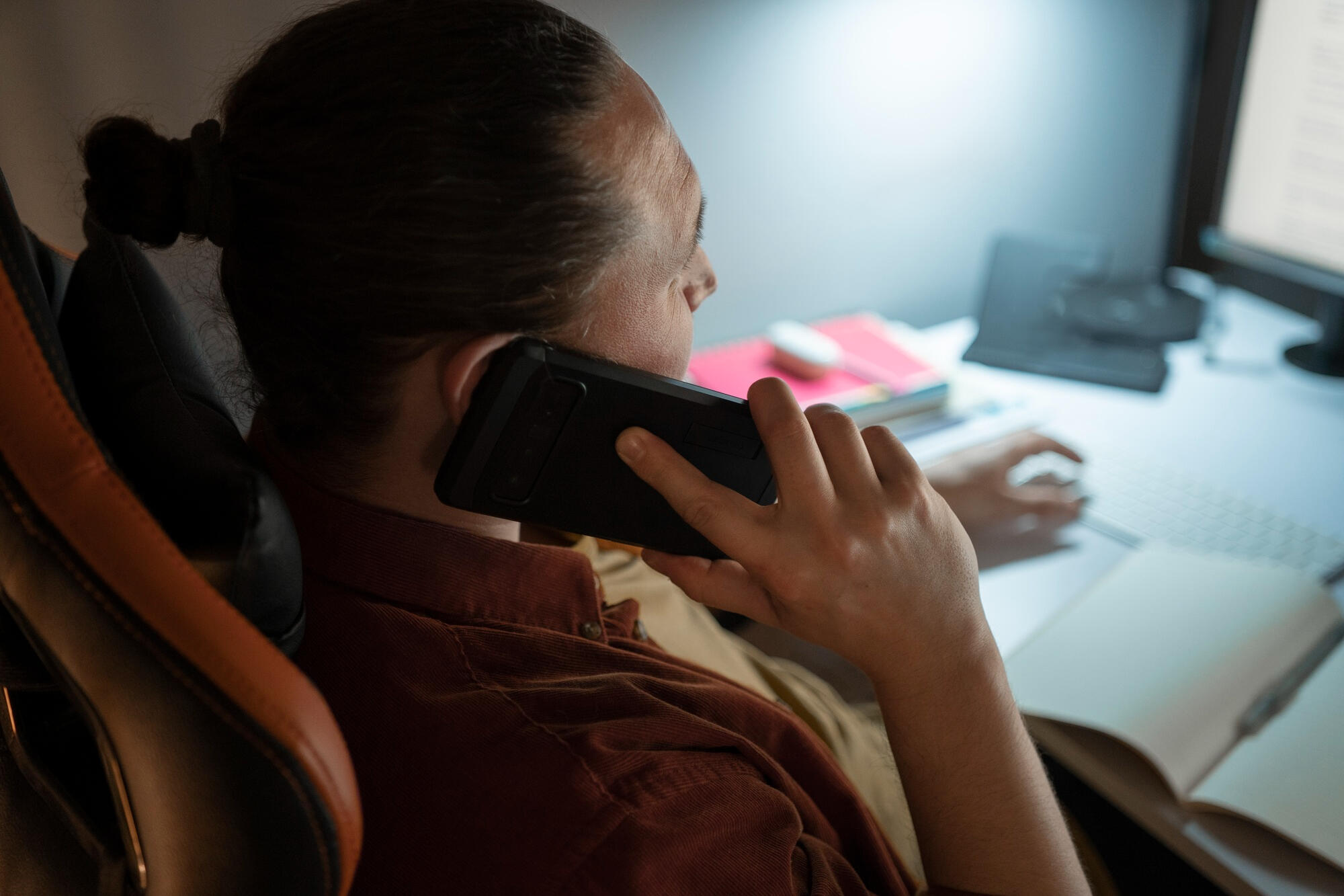 Policial sentado, falando ao telefone.