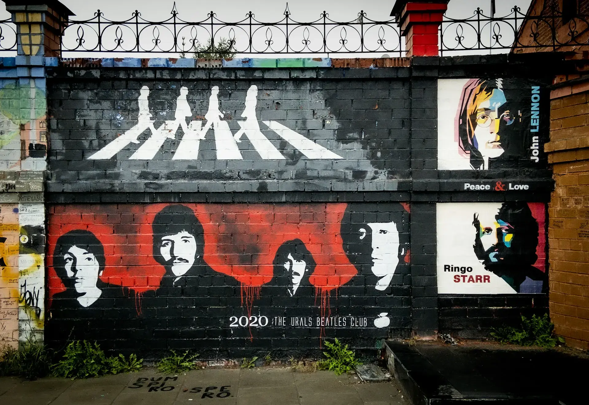 Imagem de um muro com um desenho dos Beatles.